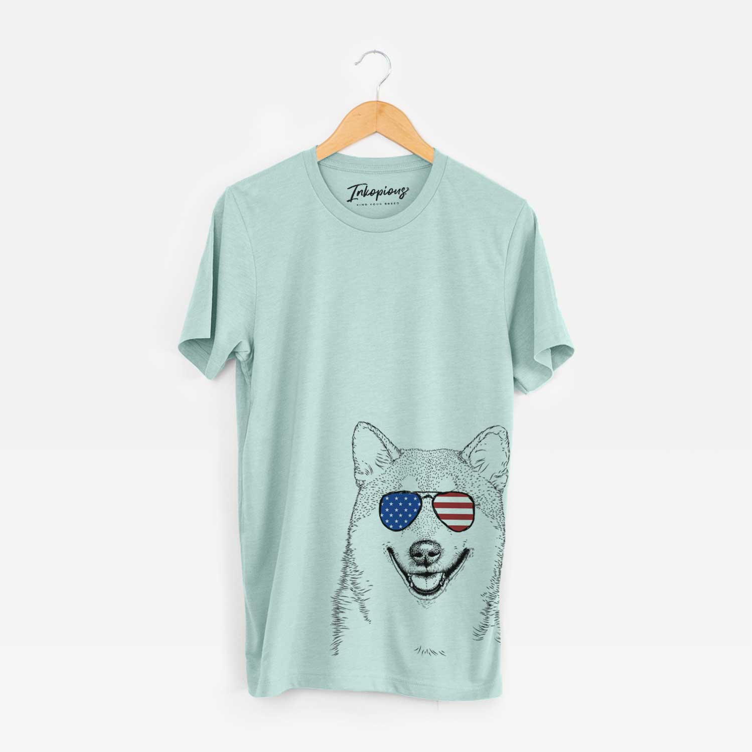 Hand-drawn sketch of Mitsu the Shiba Inu wearing American flag sunglasses on a Heather Sage Unisex crewneck
