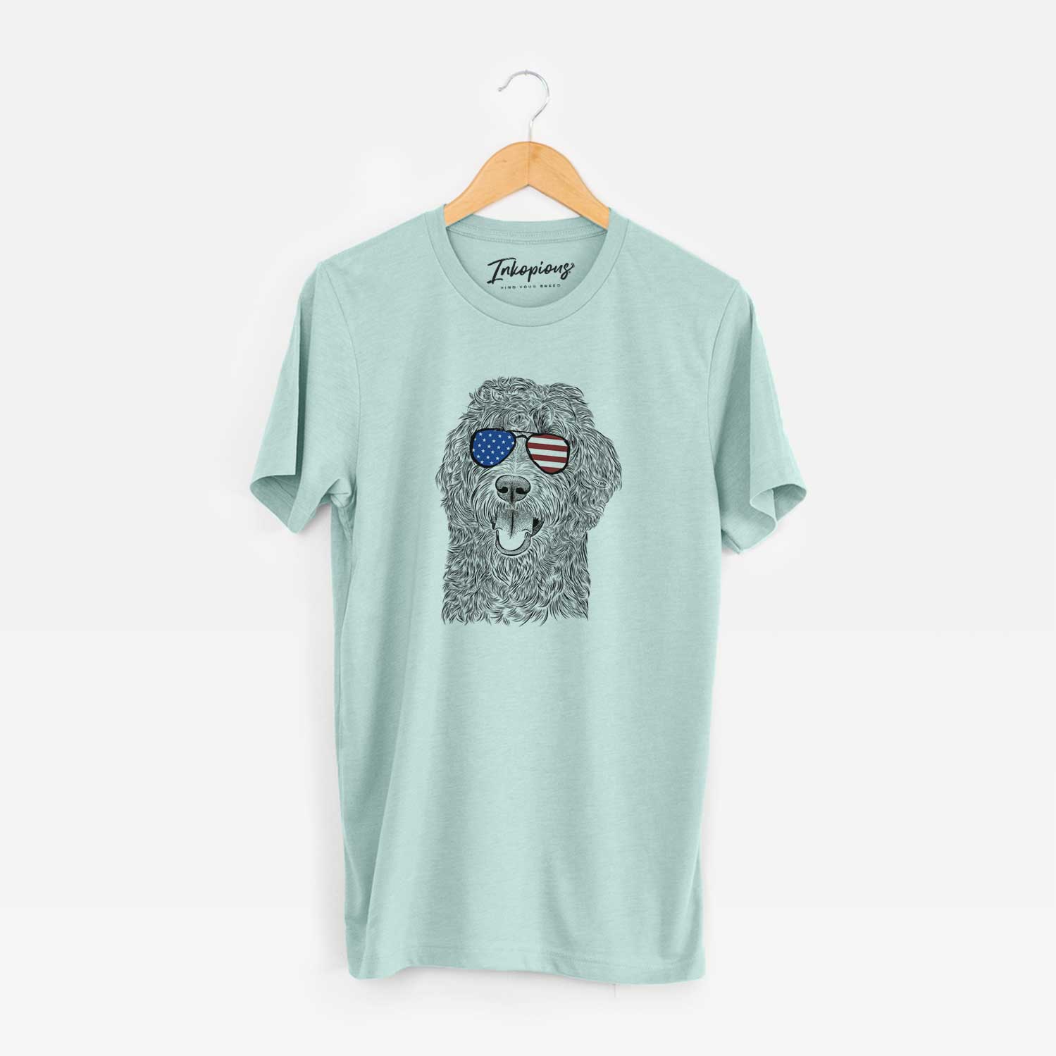Hand-drawn sketch of Murr Dog the Labradoodle wearing American flag sunglasses on a Heather Sage Unisex crewneck
