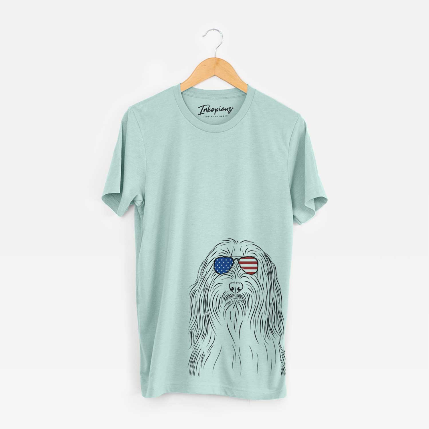 Hand-drawn sketch of Murray the Bearded Collie wearing American flag sunglasses on a Heather Sage Unisex crewneck