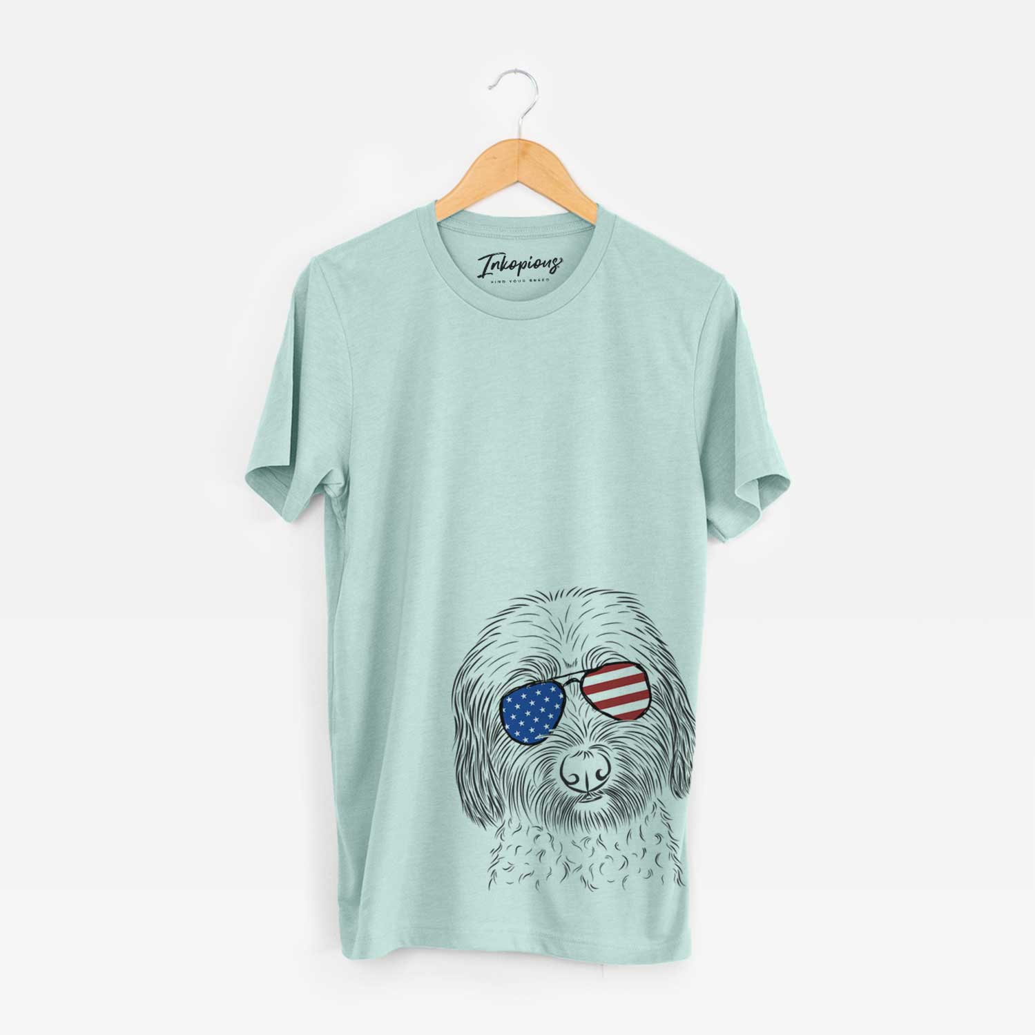 Hand-drawn sketch of Niles the Soft Coated Wheaten Terrier wearing American flag sunglasses on a Heather Sage Unisex crewneck