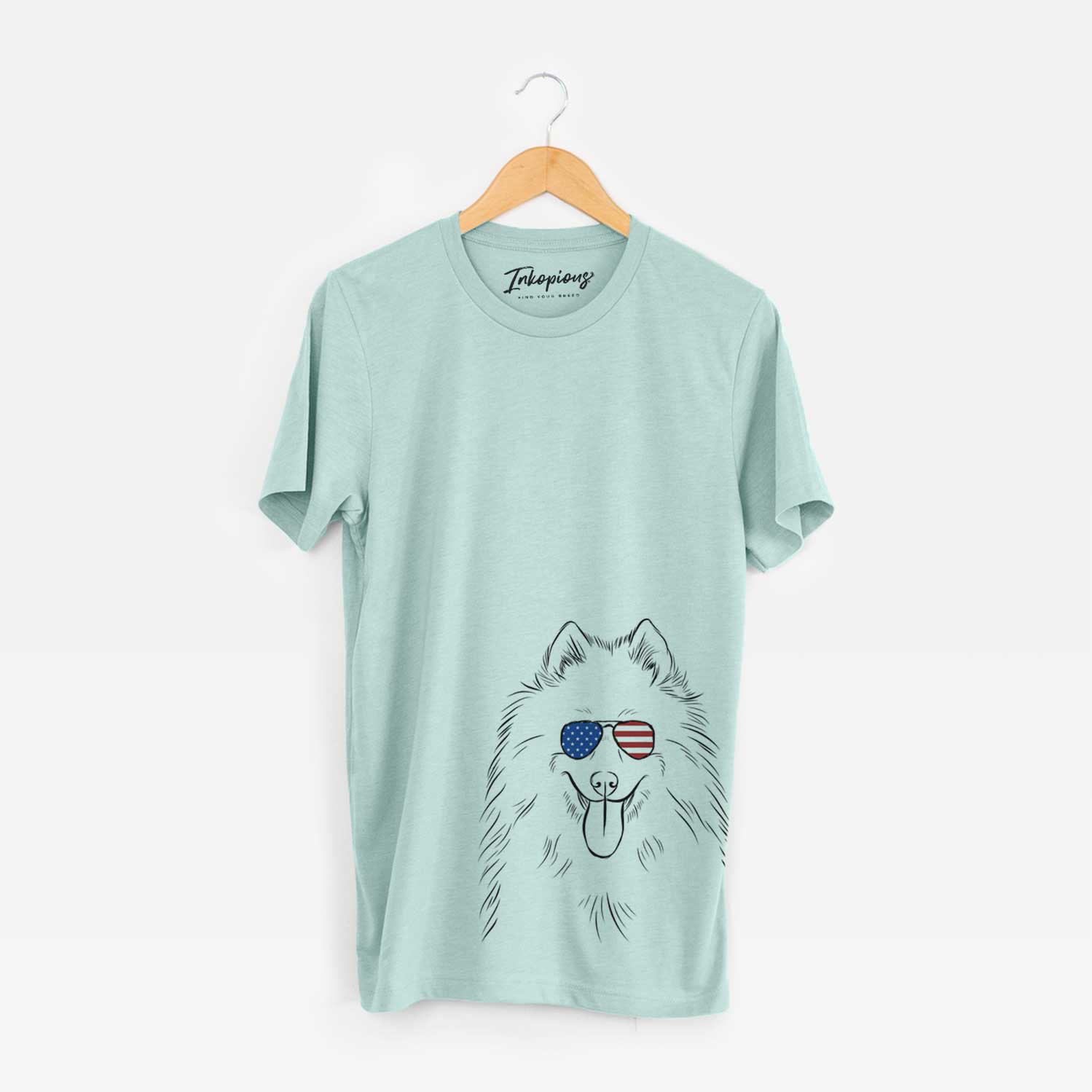 Hand-drawn sketch of Nova the Samoyed wearing American flag sunglasses on a Heather Sage Unisex crewneck