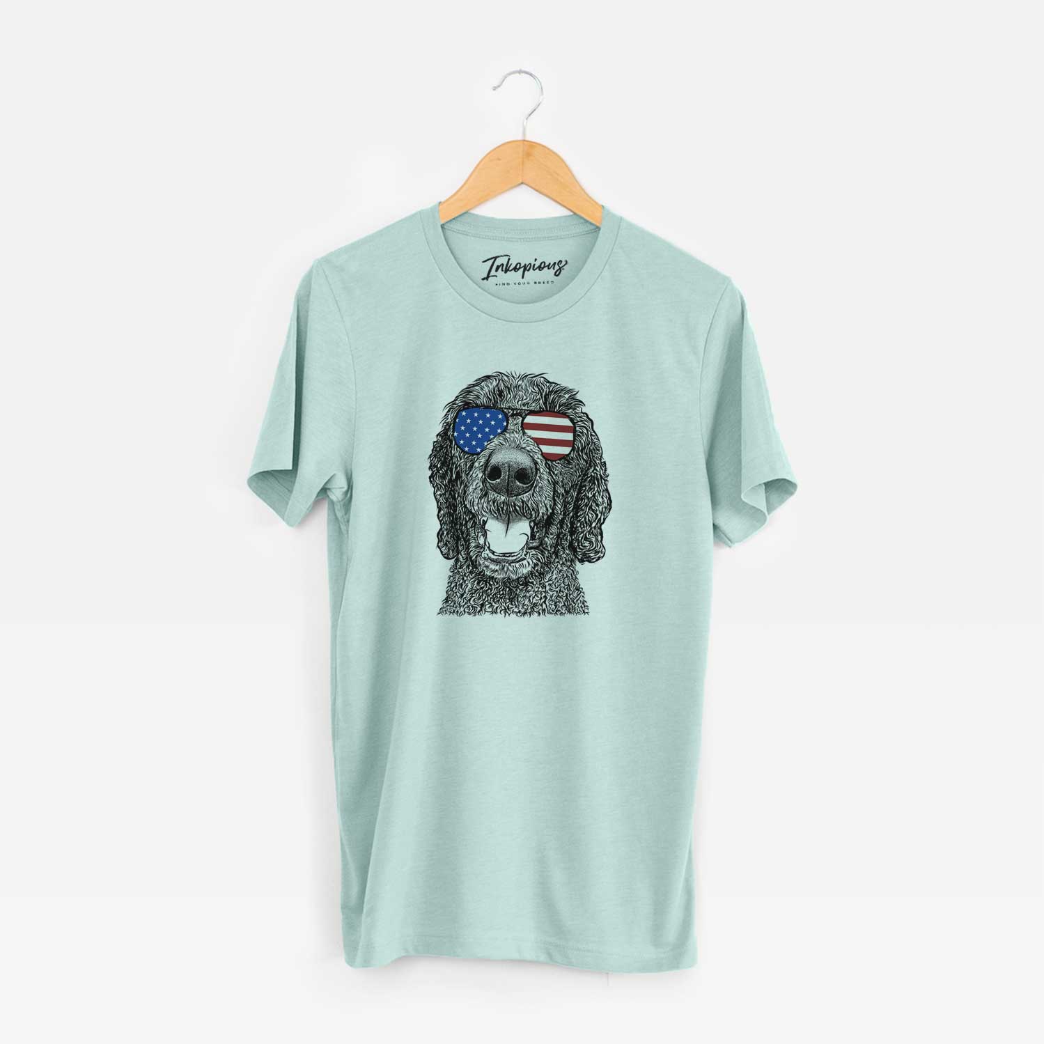Hand-drawn sketch of Obi James the Goldendoodle wearing American flag sunglasses on a Heather Sage Unisex crewneck