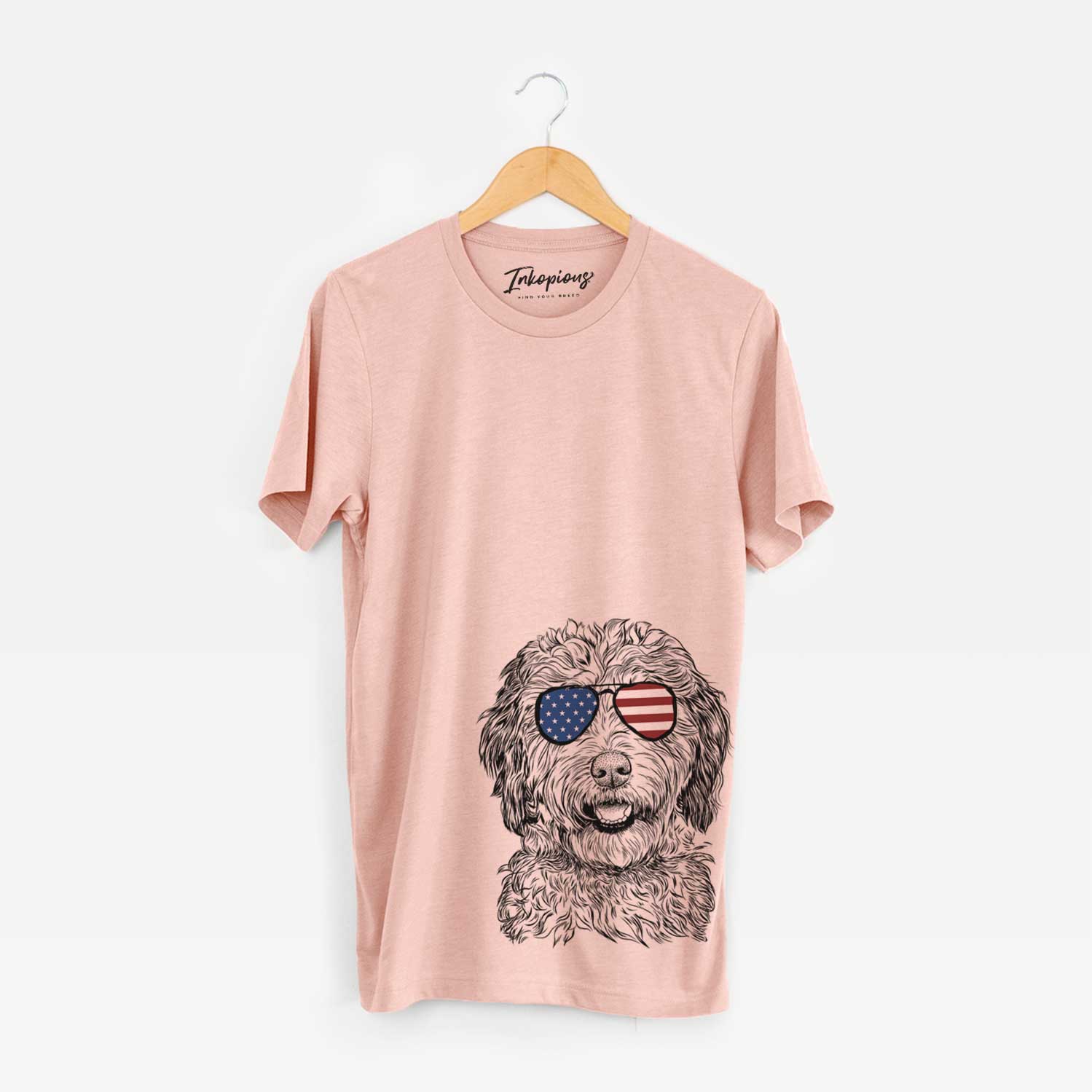 Hand-drawn sketch of Palmer the Aussiedoodle wearing American flag sunglasses on a Peach Unisex crewneck
