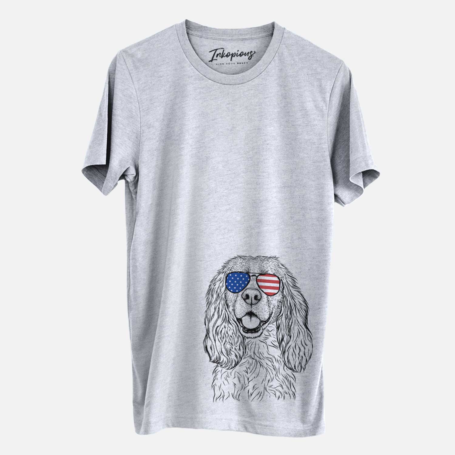 Hand-drawn sketch of Perry the Cockalier wearing American flag sunglasses on a Grey Unisex crewneck