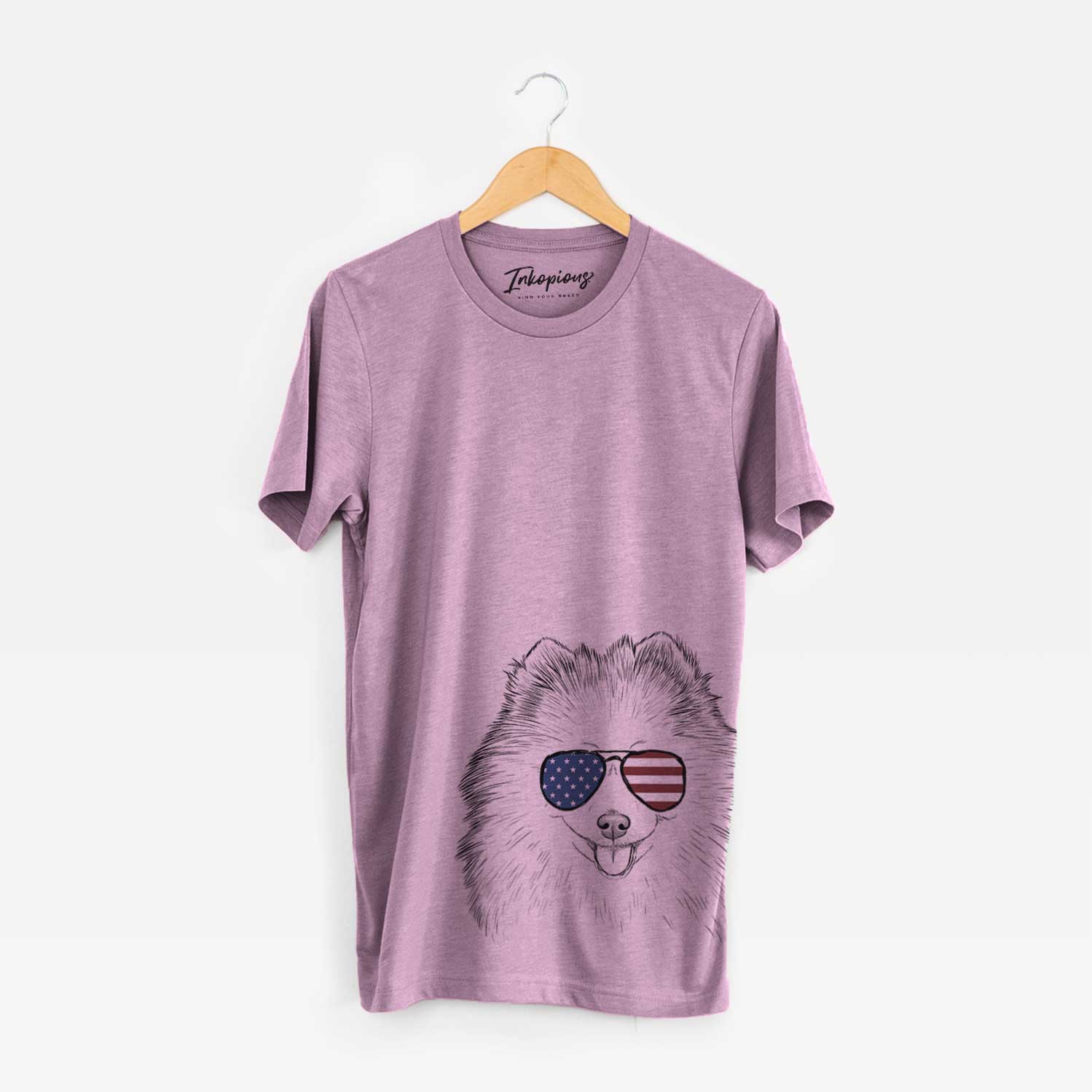 Hand-drawn sketch of Piper Jo the Pomeranian wearing American flag sunglasses on an Orchid Unisex crewneck