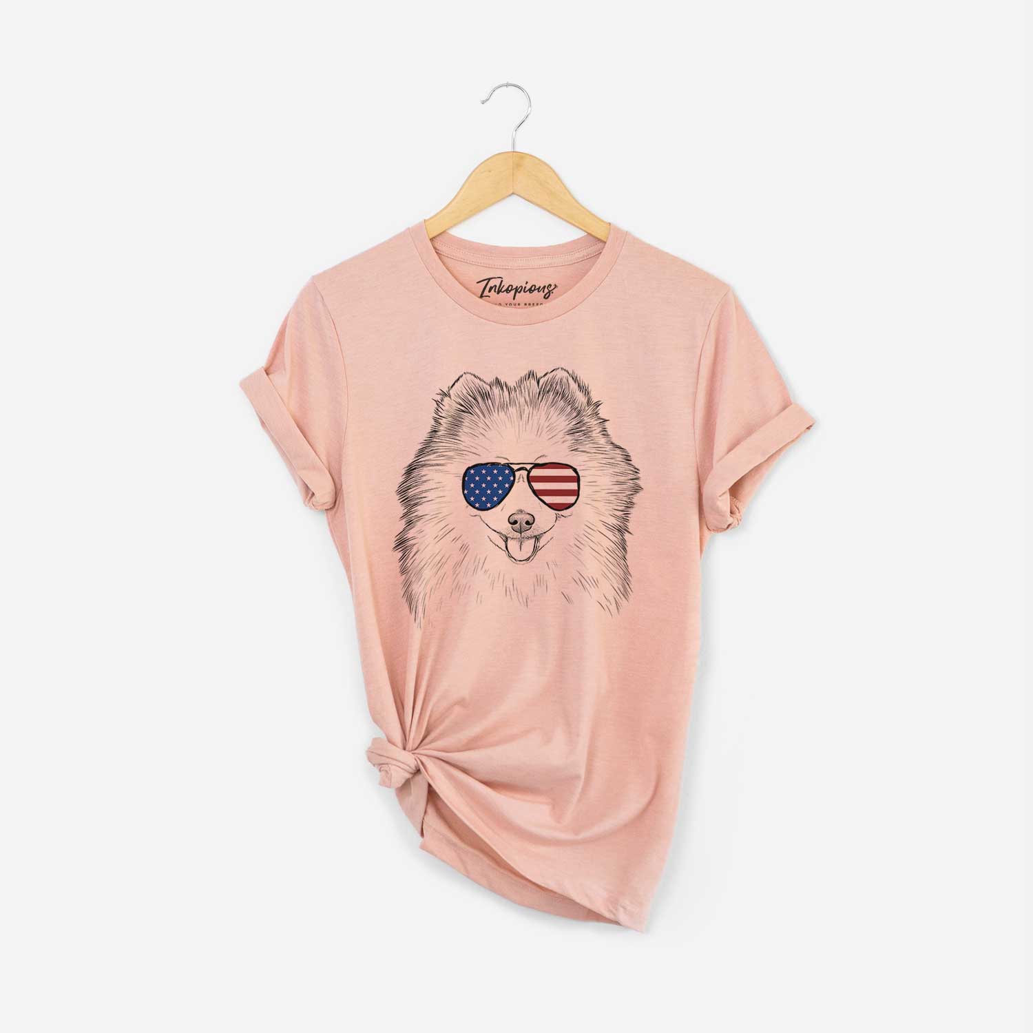 Hand-drawn sketch of Piper Jo the Pomeranian wearing American flag sunglasses on a Peach Unisex crewneck