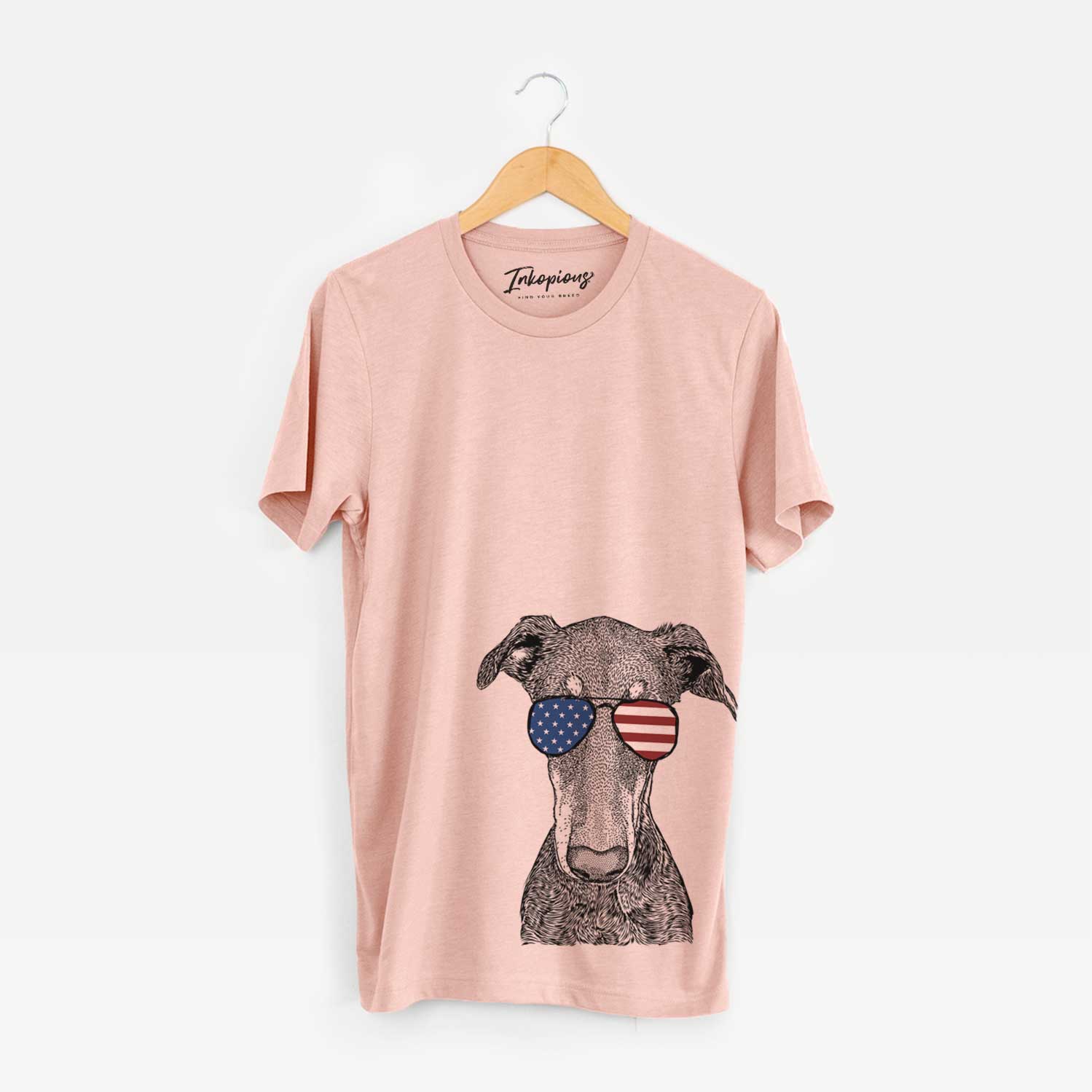 Hand-drawn sketch of Princess Fiona the Doberman Pinscher wearing American flag sunglasses on a Peach Unisex crewneck