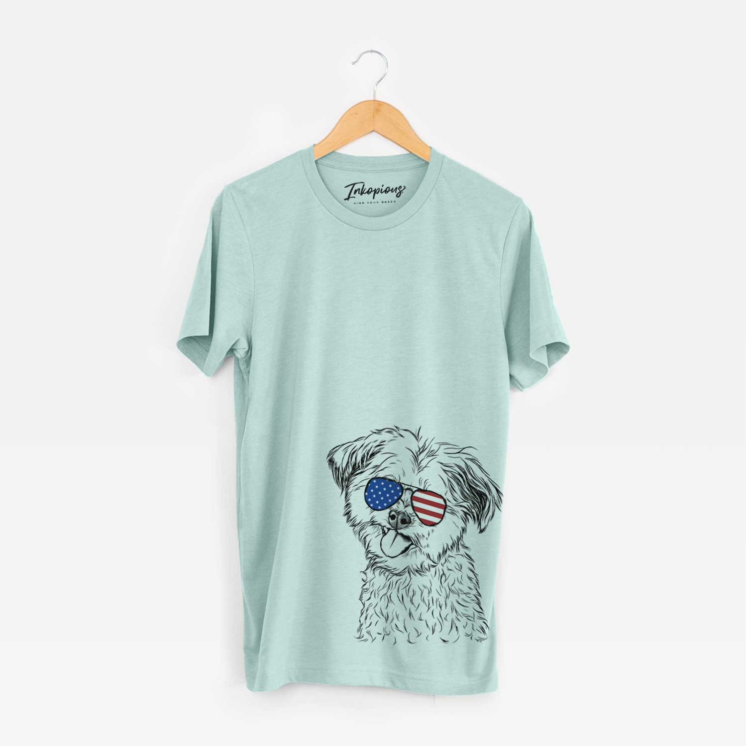 Hand-drawn sketch of Puff the Malshi wearing American flag sunglasses on a Heather Sage Unisex crewneck