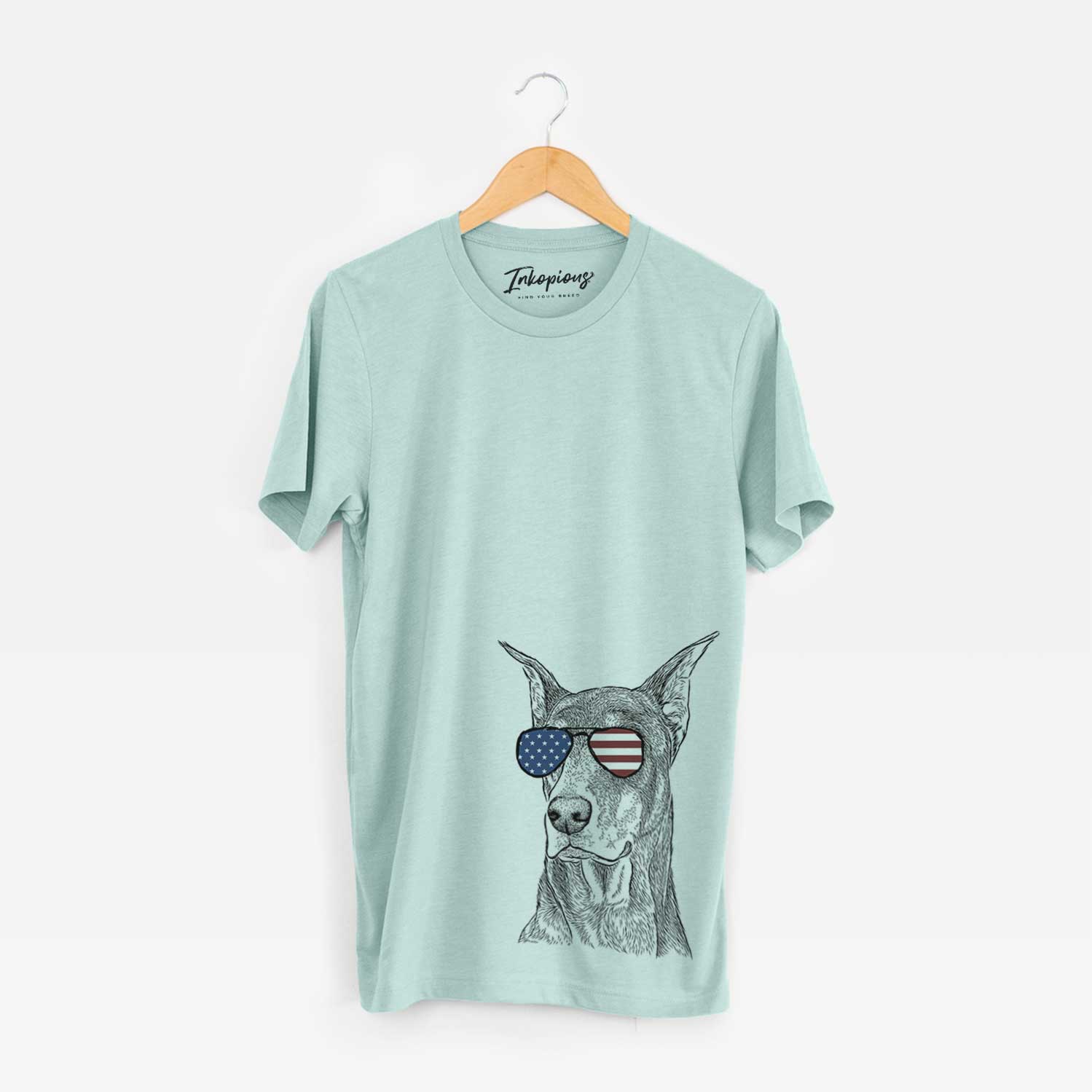 Hand-drawn sketch of RJ the Doberman Pinscher wearing American flag sunglasses on a Heather Sage Unisex crewneck