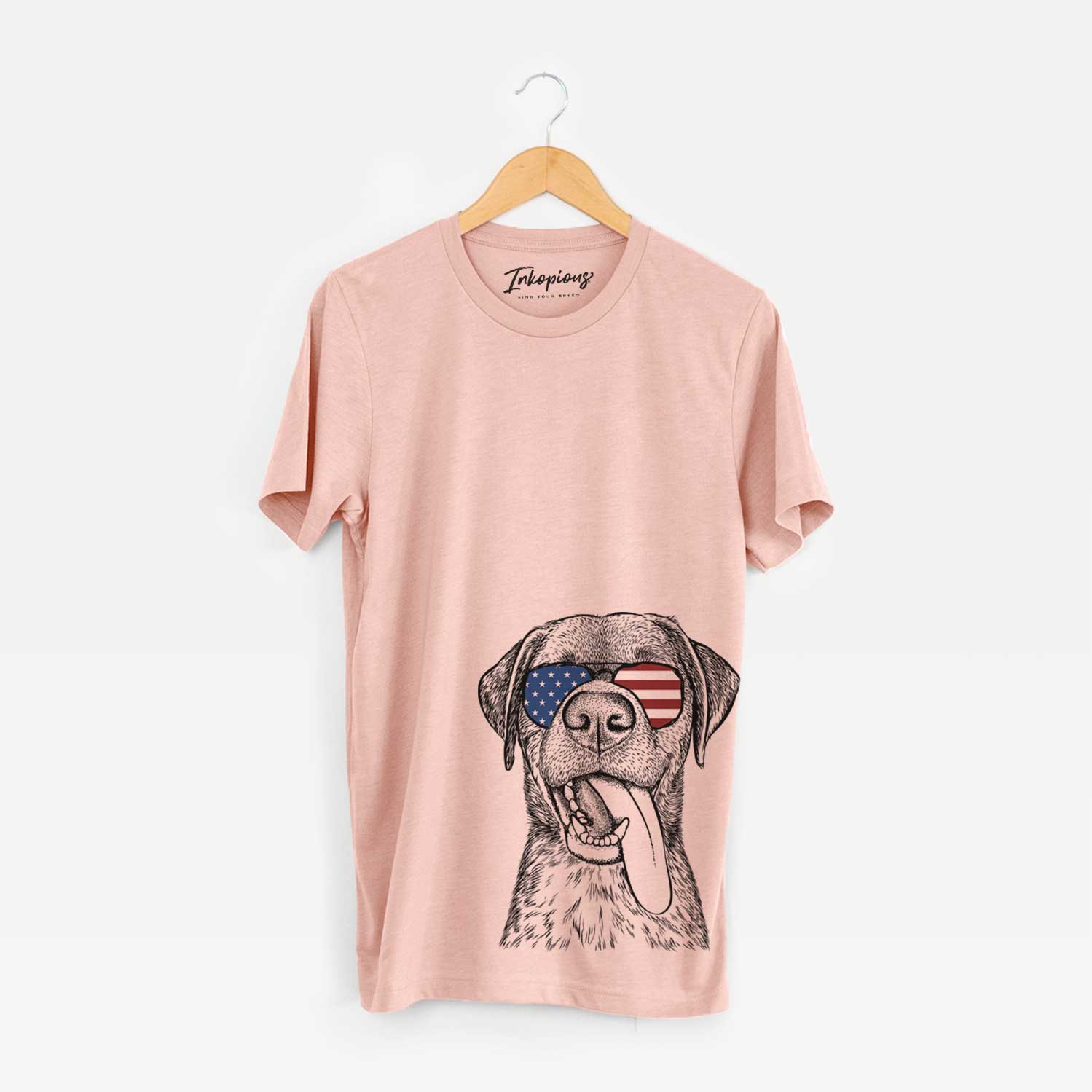 Hand-drawn sketch of Reese the Mixed Breed wearing American flag sunglasses on a Peach Unisex crewneck