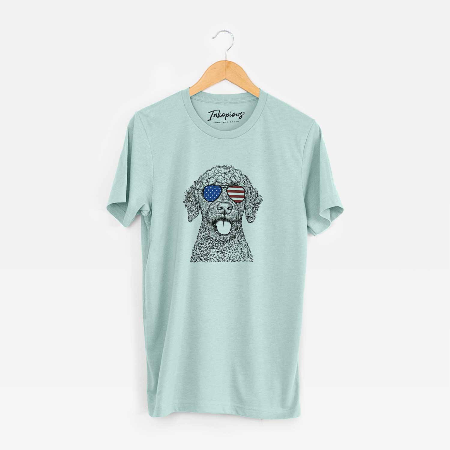 Hand-drawn sketch of Reina the Spanish Water Dog wearing American flag sunglasses on a Heather Sage Unisex crewneck