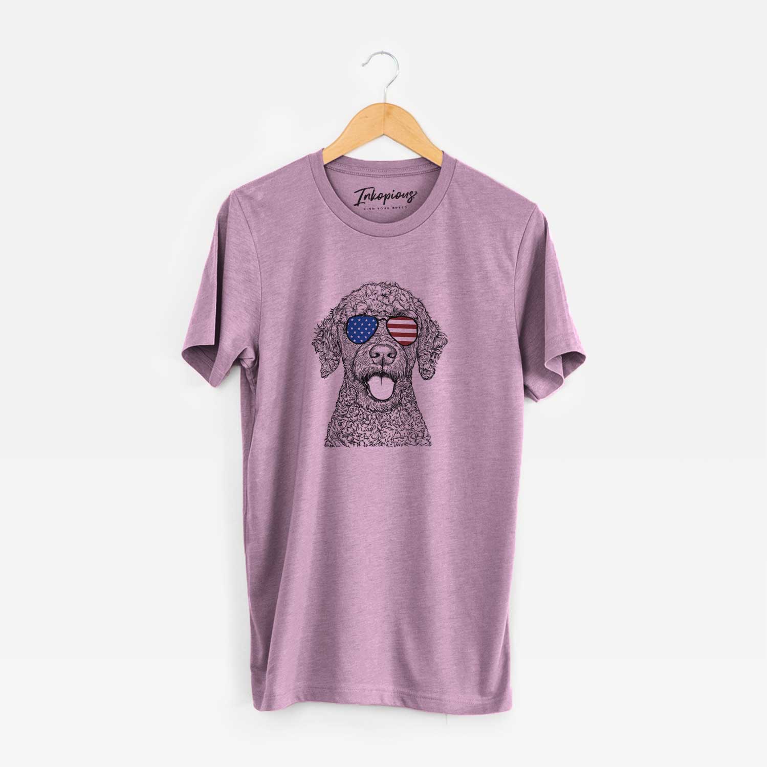 Hand-drawn sketch of Reina the Spanish Water Dog wearing American flag sunglasses on an Orchid Unisex crewneck