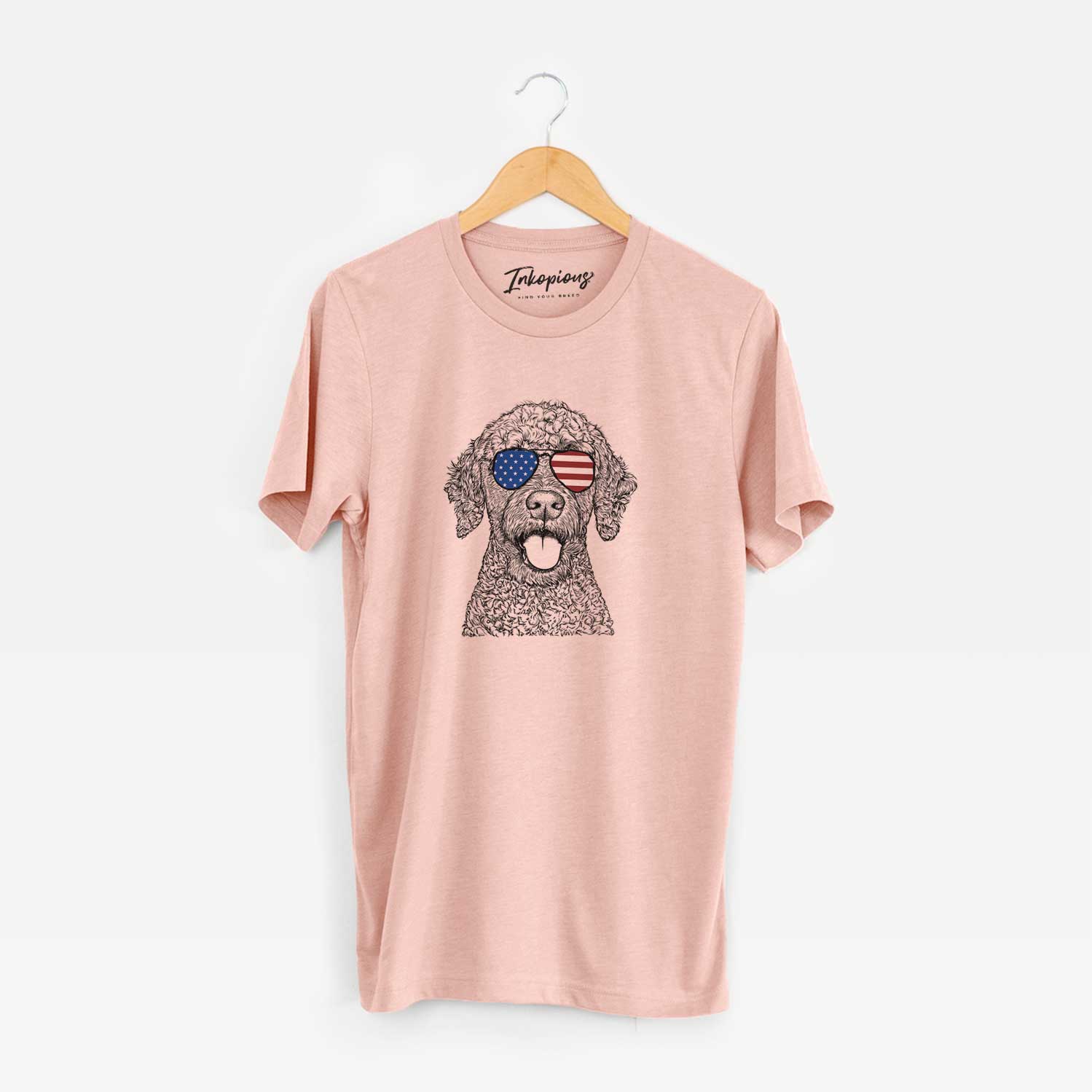 Hand-drawn sketch of Reina the Spanish Water Dog wearing American flag sunglasses on a Peach Unisex crewneck