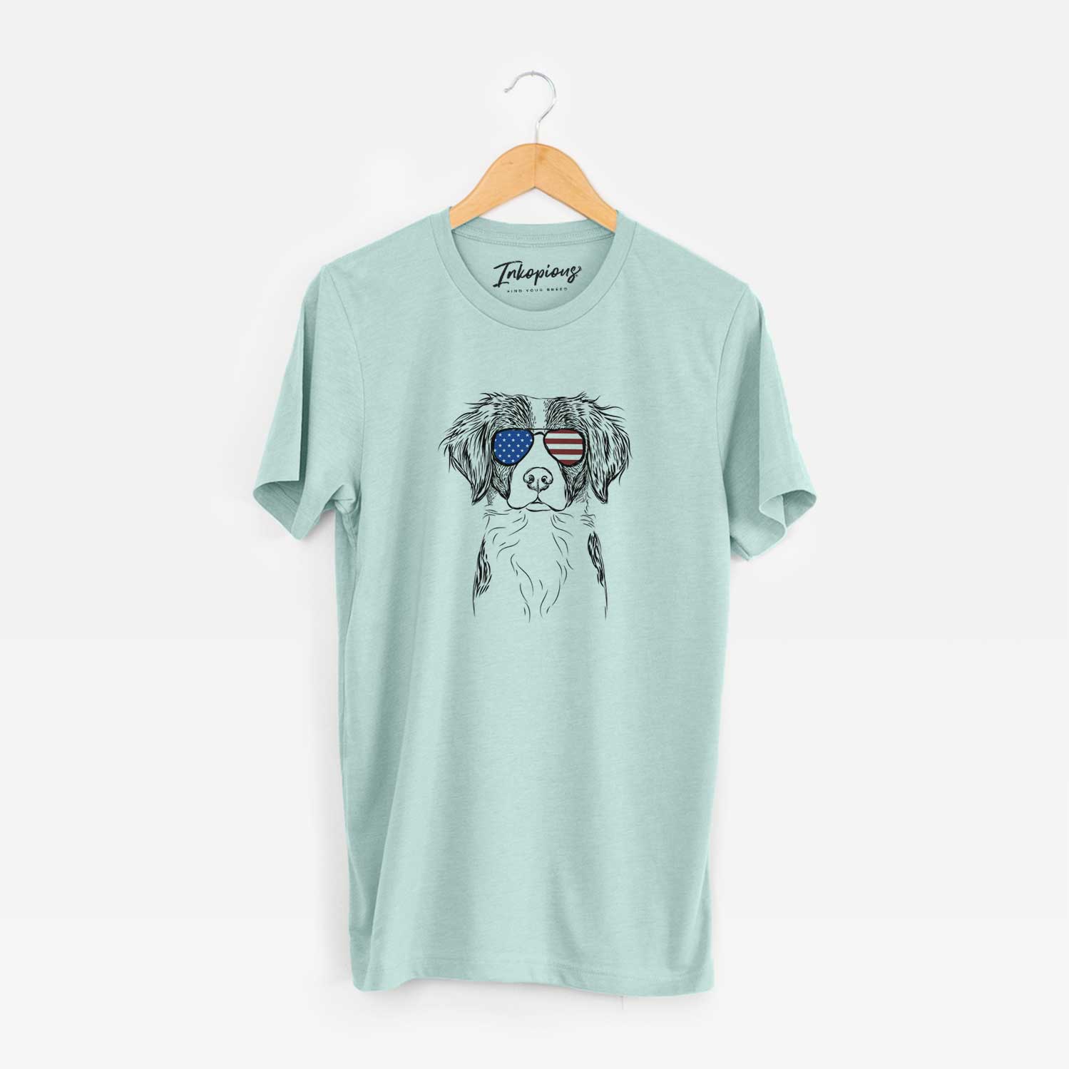 Hand-drawn sketch of Remi the Brittany wearing American flag sunglasses on a Heather Sage Unisex crewneck