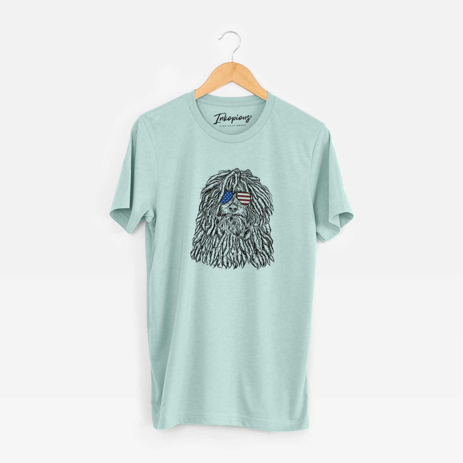 Hand-drawn sketch of Rezi the Puli wearing American flag sunglasses on a Heather Sage Unisex crewneck