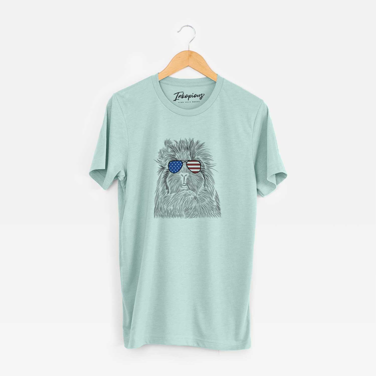 Hand-drawn sketch of Rhino the Guinea Pig wearing American flag sunglasses on a Heather Sage Unisex crewneck