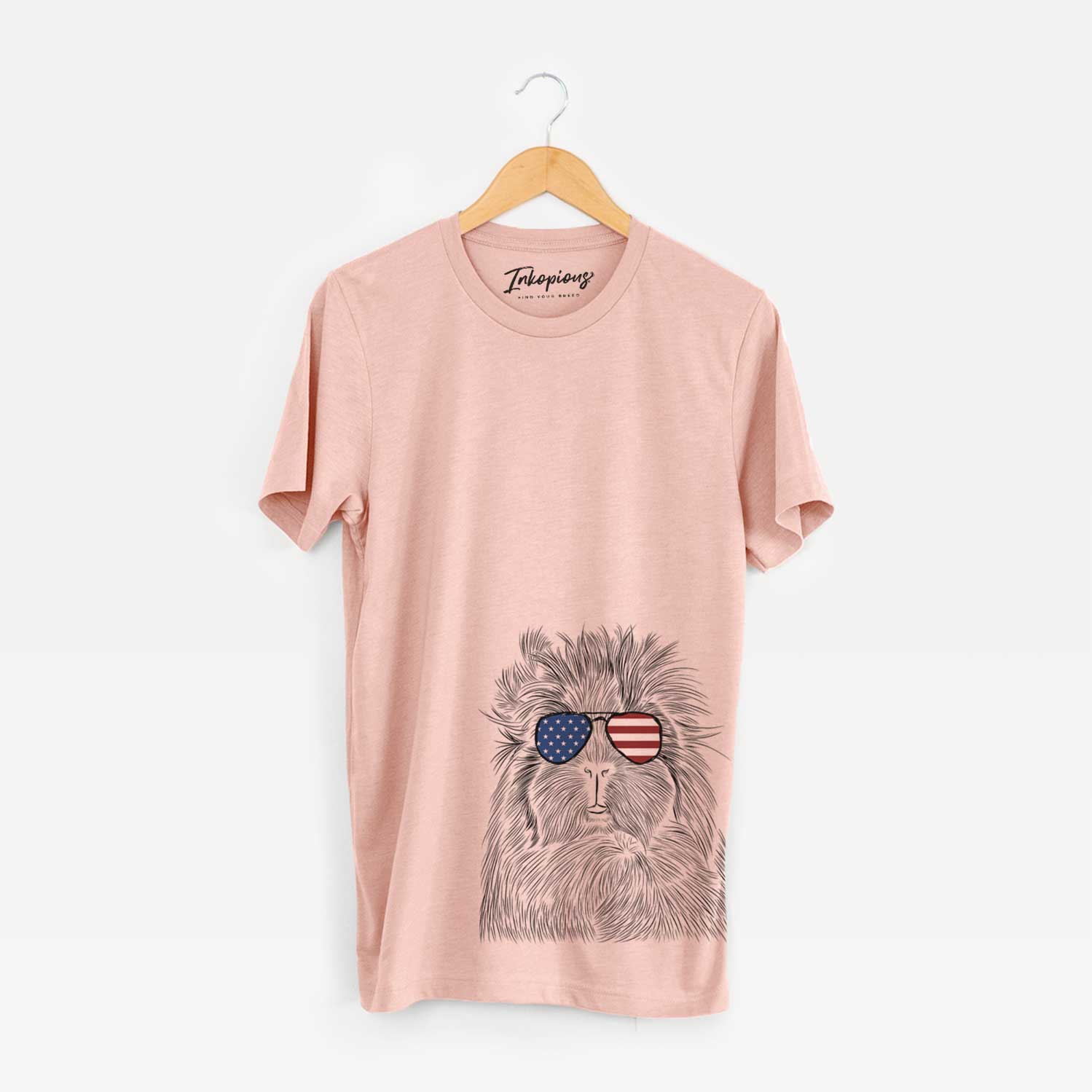 Hand-drawn sketch of Rhino the Guinea Pig wearing American flag sunglasses on a Peach Unisex crewneck
