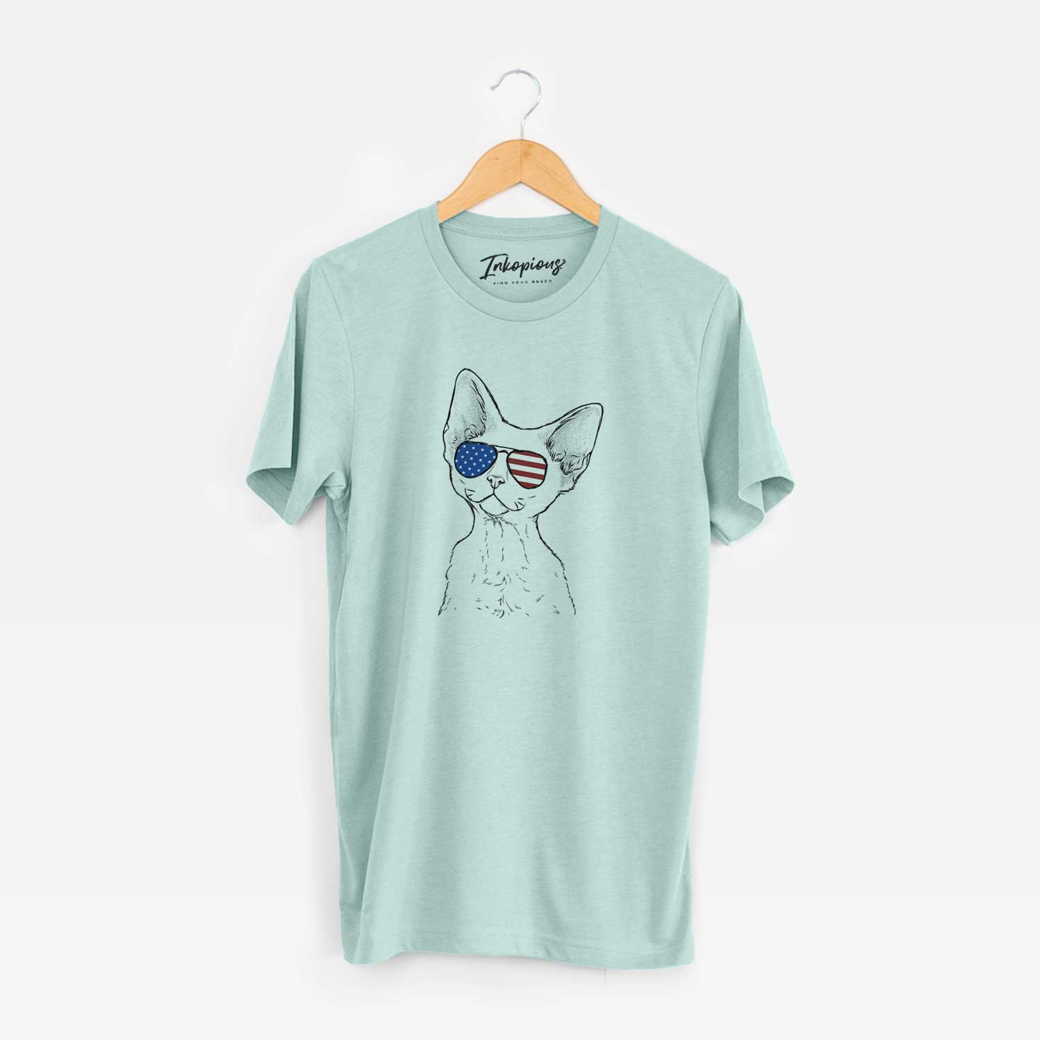 Hand-drawn sketch of Ripley the Devon Rex Cat wearing American flag sunglasses on a Heather Sage Unisex crewneck