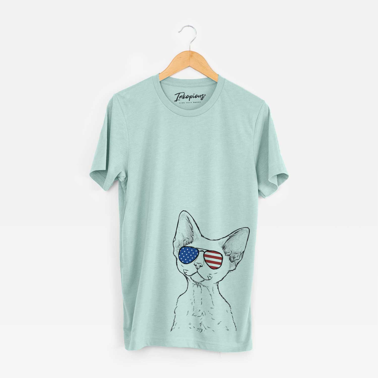Hand-drawn sketch of Ripley the Devon Rex Cat wearing American flag sunglasses on a Heather Sage Unisex crewneck