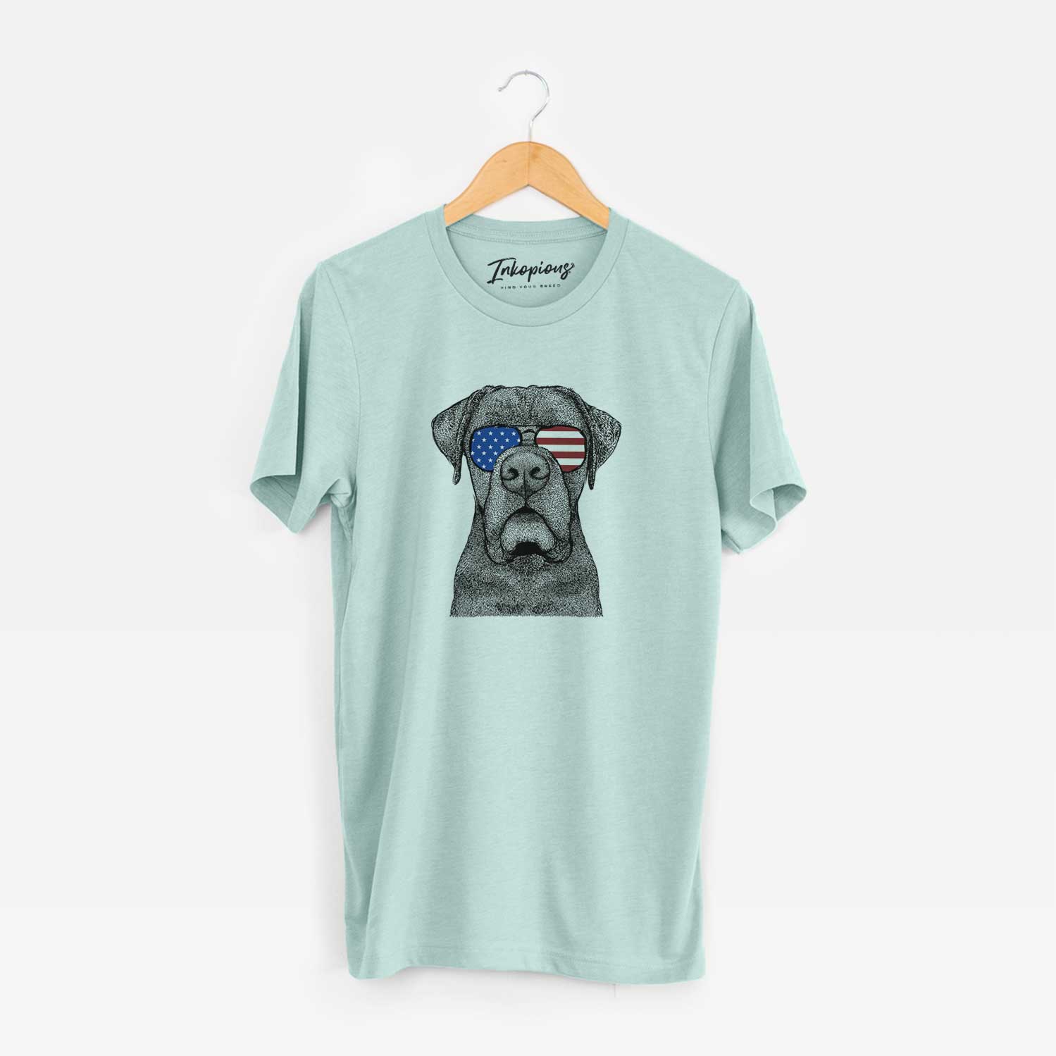 Hand-drawn sketch of Rocco the Cane Corso wearing American flag sunglasses on a Heather Sage Unisex crewneck