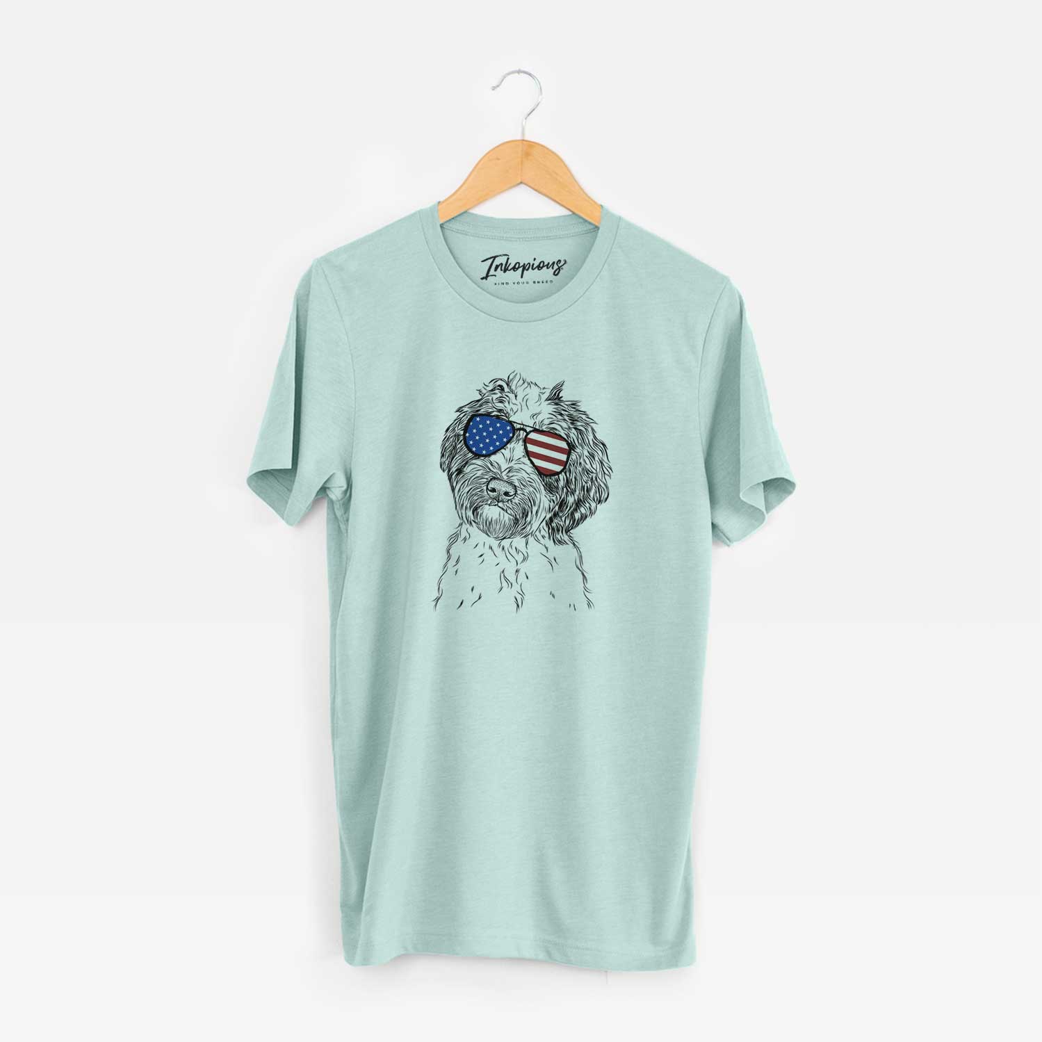 Hand-drawn sketch of Rooney the Aussiedoodle wearing American flag sunglasses on a Heather Sage Unisex crewneck
