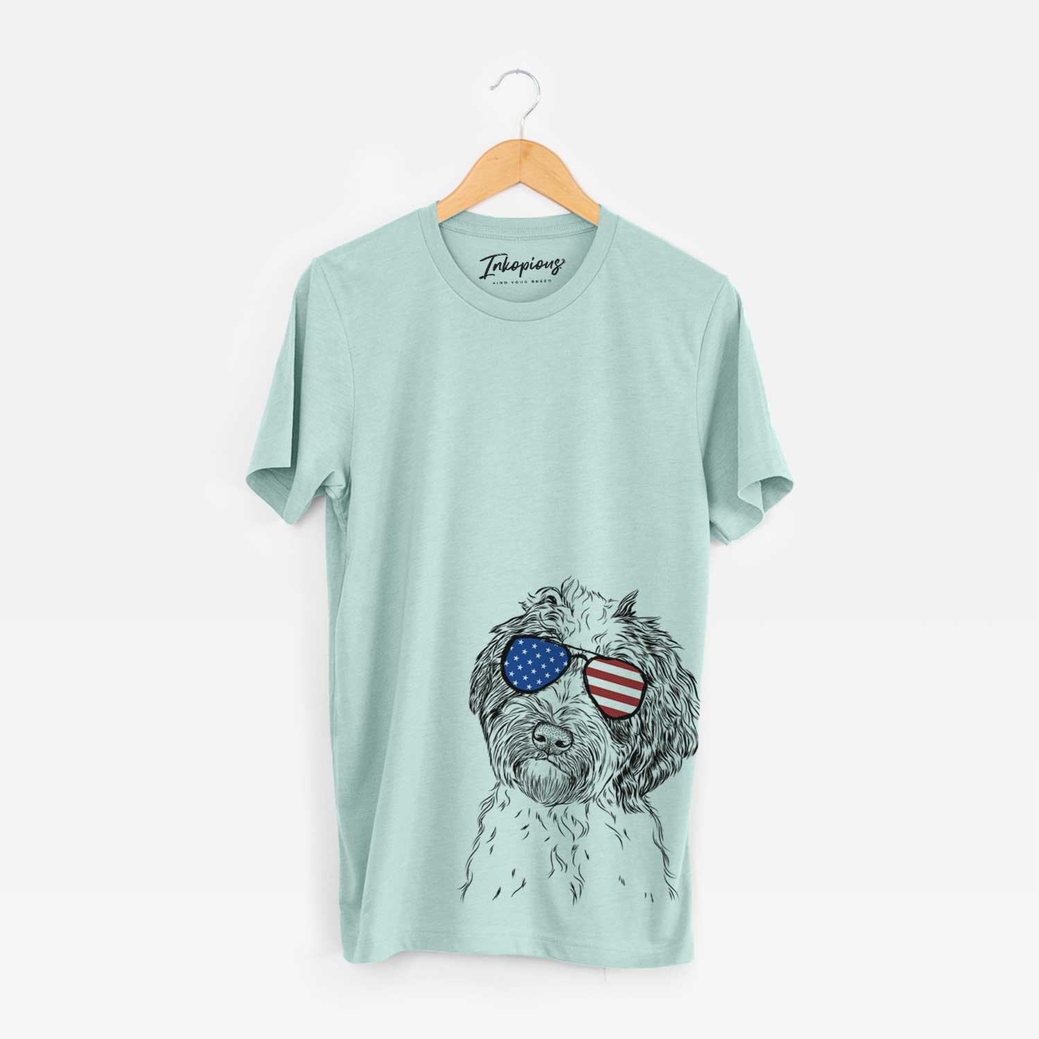 Hand-drawn sketch of Rooney the Aussiedoodle wearing American flag sunglasses on a Heather Sage Unisex crewneck