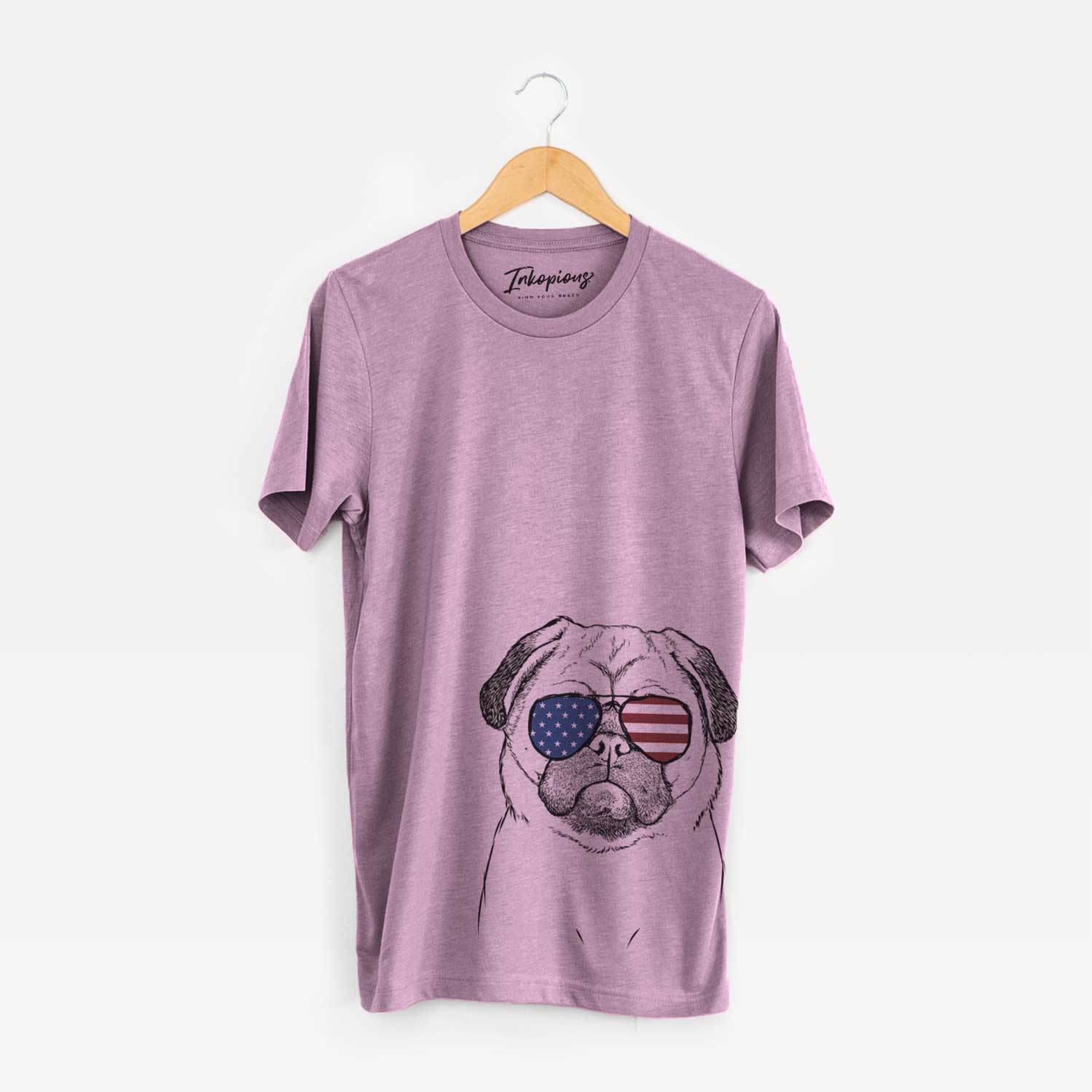 Hand-drawn sketch of Ruby the Pug wearing American flag sunglasses on an Orchid Unisex crewneck