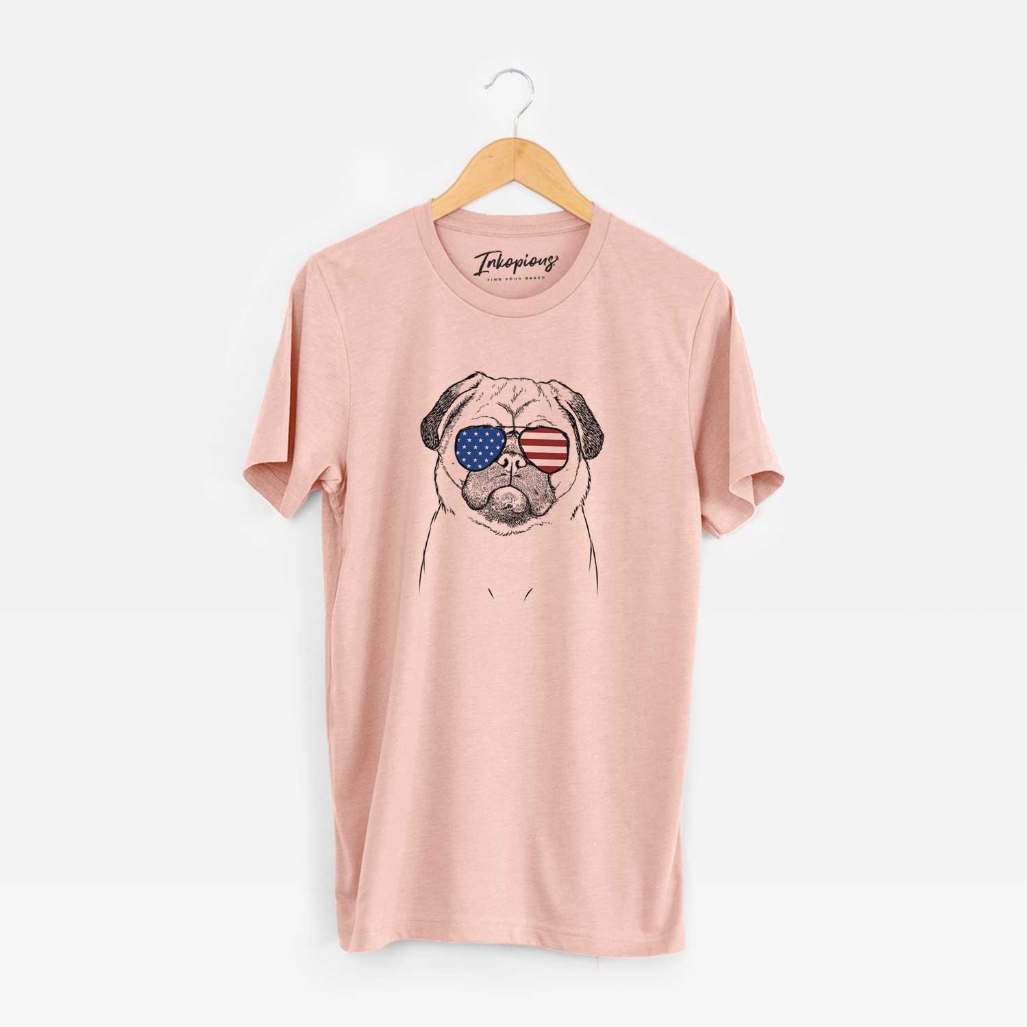 Hand-drawn sketch of Ruby the Pug wearing American flag sunglasses on a Peach Unisex crewneck