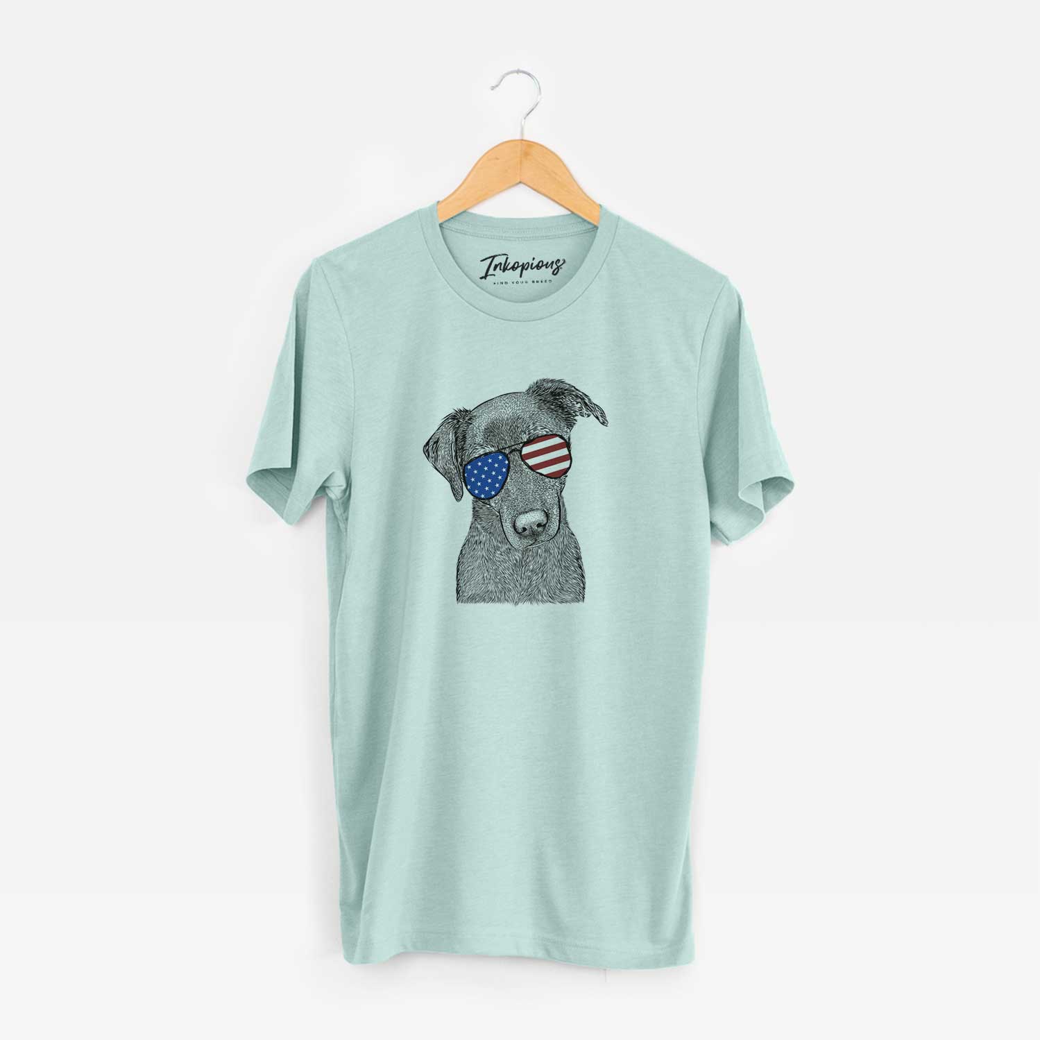 Hand-drawn sketch of Sadie the Whipador wearing American flag sunglasses on a Heather Sage Unisex crewneck