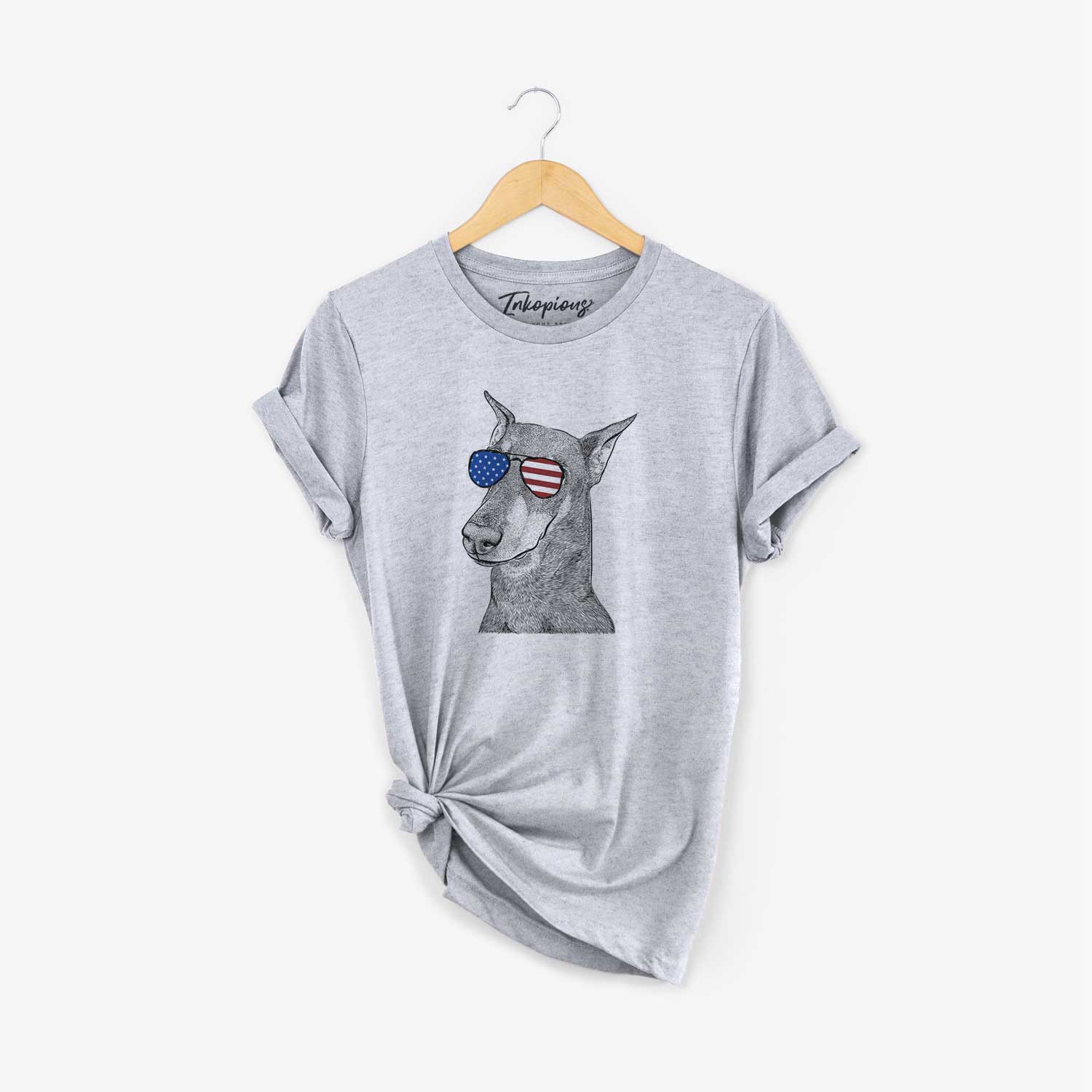 Hand-drawn sketch of Shelby the Doberman Pinscher wearing American flag sunglasses on a Grey Unisex crewneck