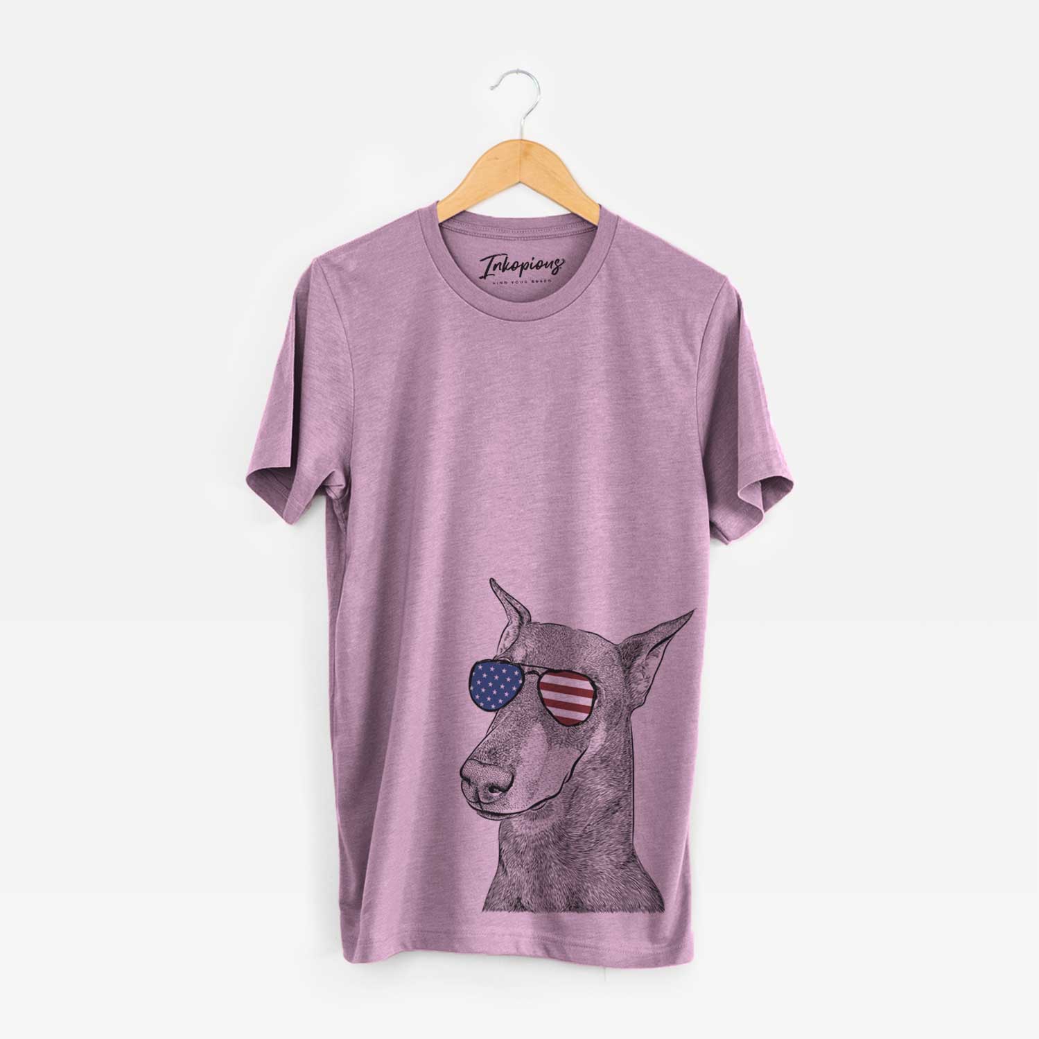 Hand-drawn sketch of Shelby the Doberman Pinscher wearing American flag sunglasses on an Orchid Unisex crewneck
