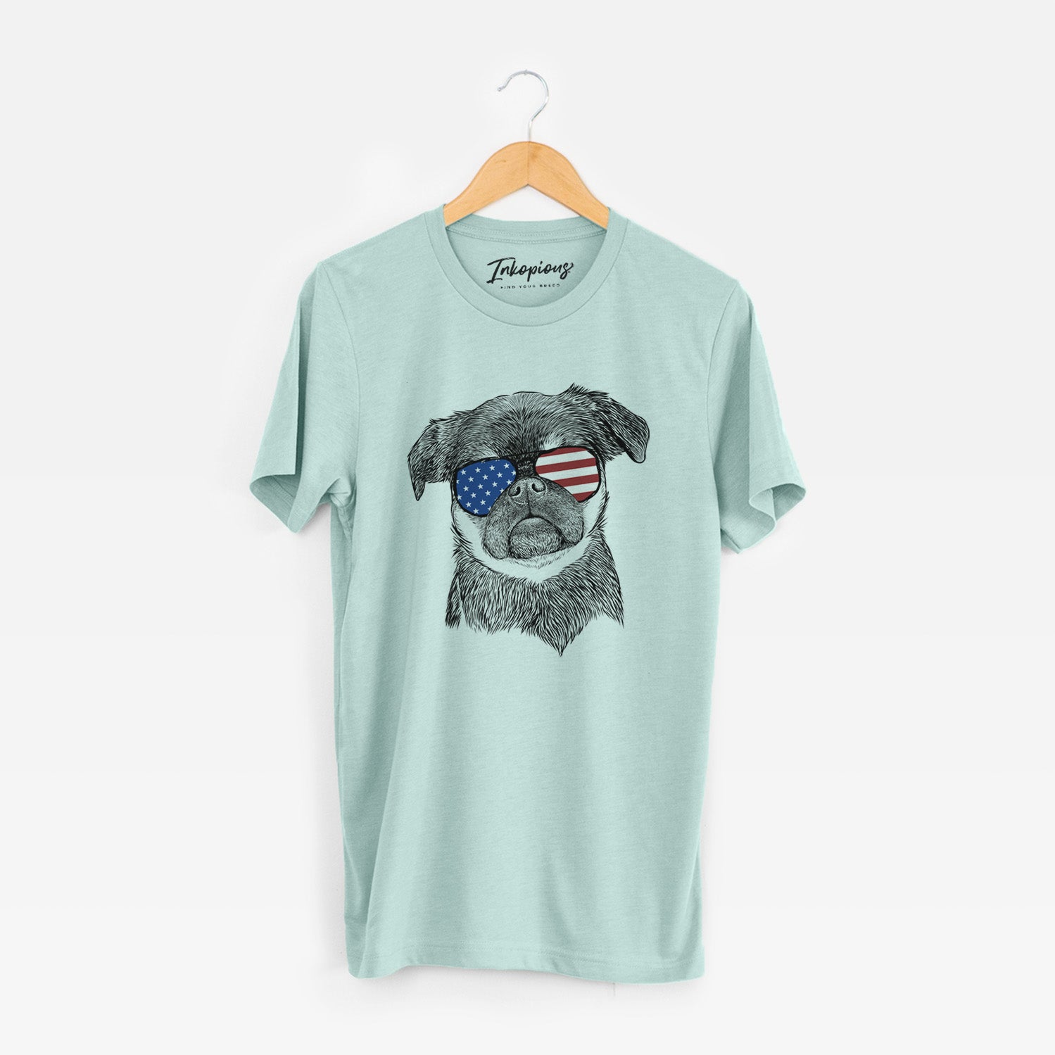 Hand-drawn sketch of Simone the Brussels Griffon wearing American flag sunglasses on a Heather Sage Unisex crewneck