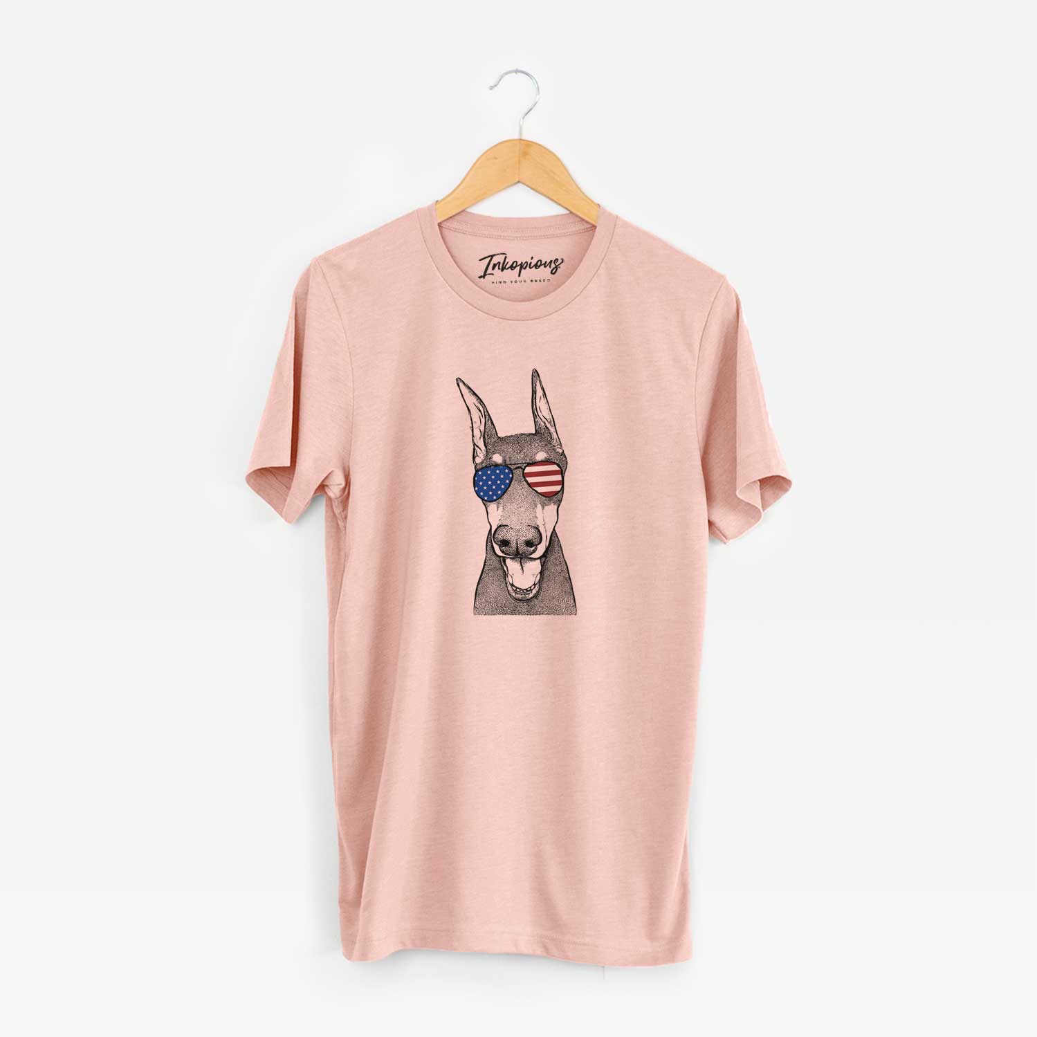 Hand-drawn sketch of Sir Duke the Doberman Pinscher wearing American flag sunglasses on a Peach Unisex crewneck