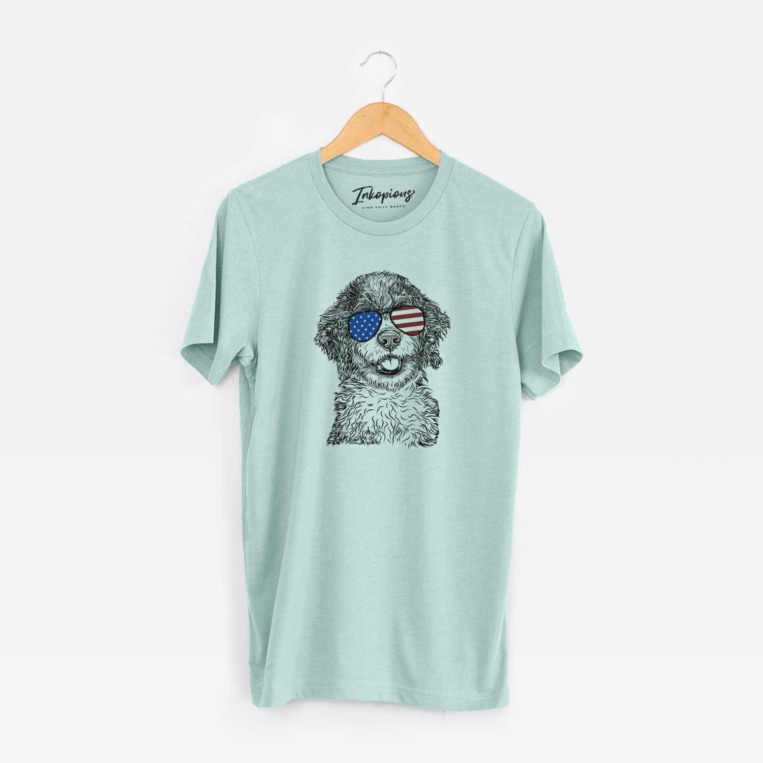 Hand-drawn sketch of Smoky the Bernedoodle Puppy wearing American flag sunglasses on a Heather Sage Unisex crewneck