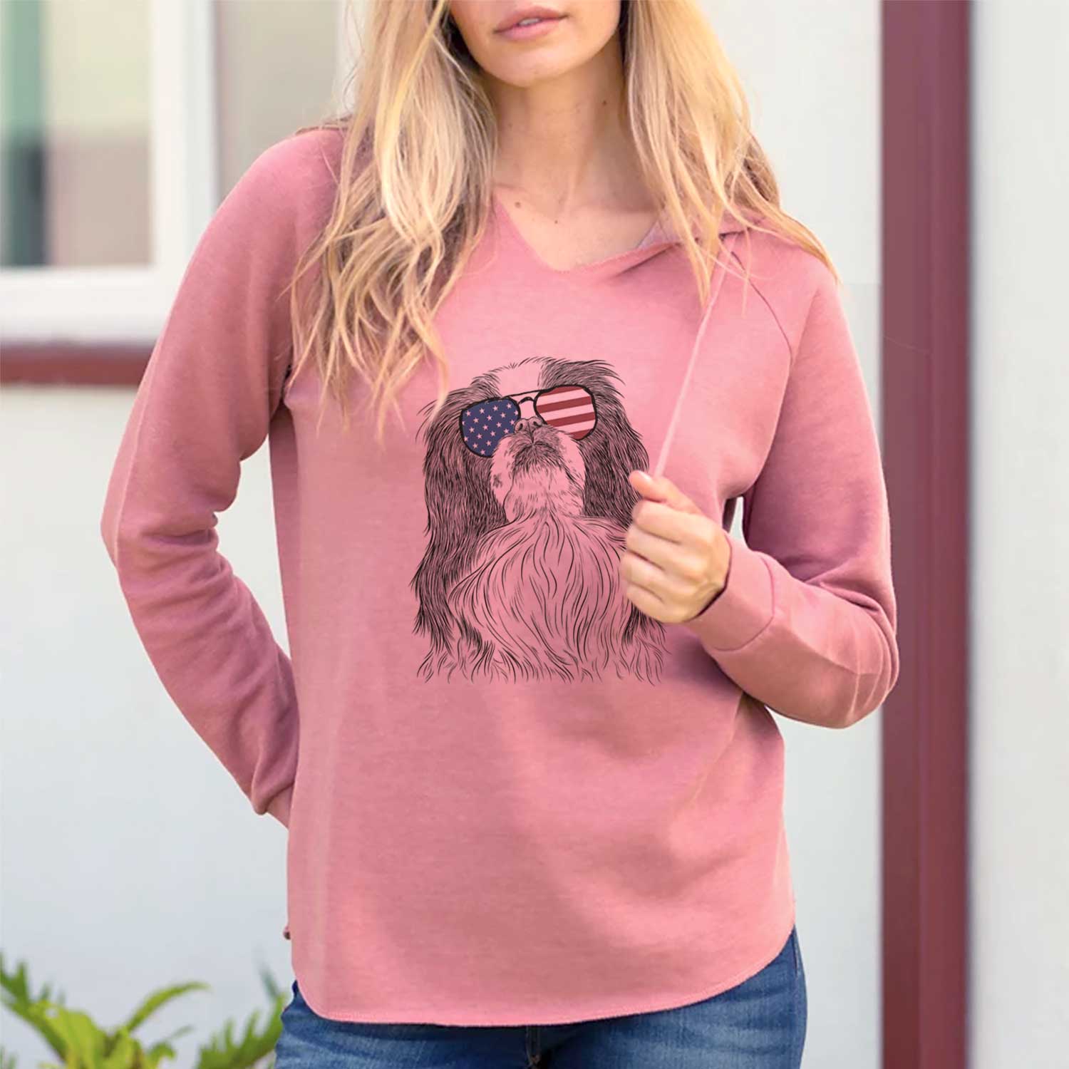 Hand-drawn sketch of Suki the Japanese Chin wearing American flag sunglasses on a Dusty Rose Cali Wave Hooded Sweatshirt, lifestyle photo