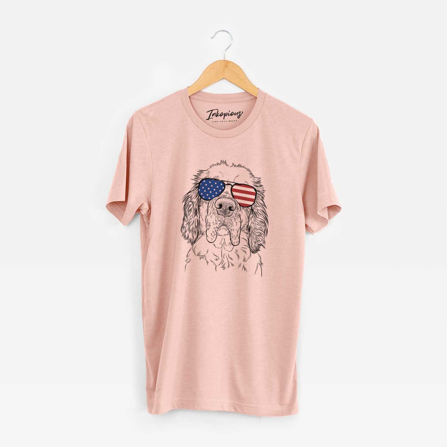 Hand-drawn sketch of Sully the Clumber Spaniel wearing American flag sunglasses on a Peach Unisex crewneck