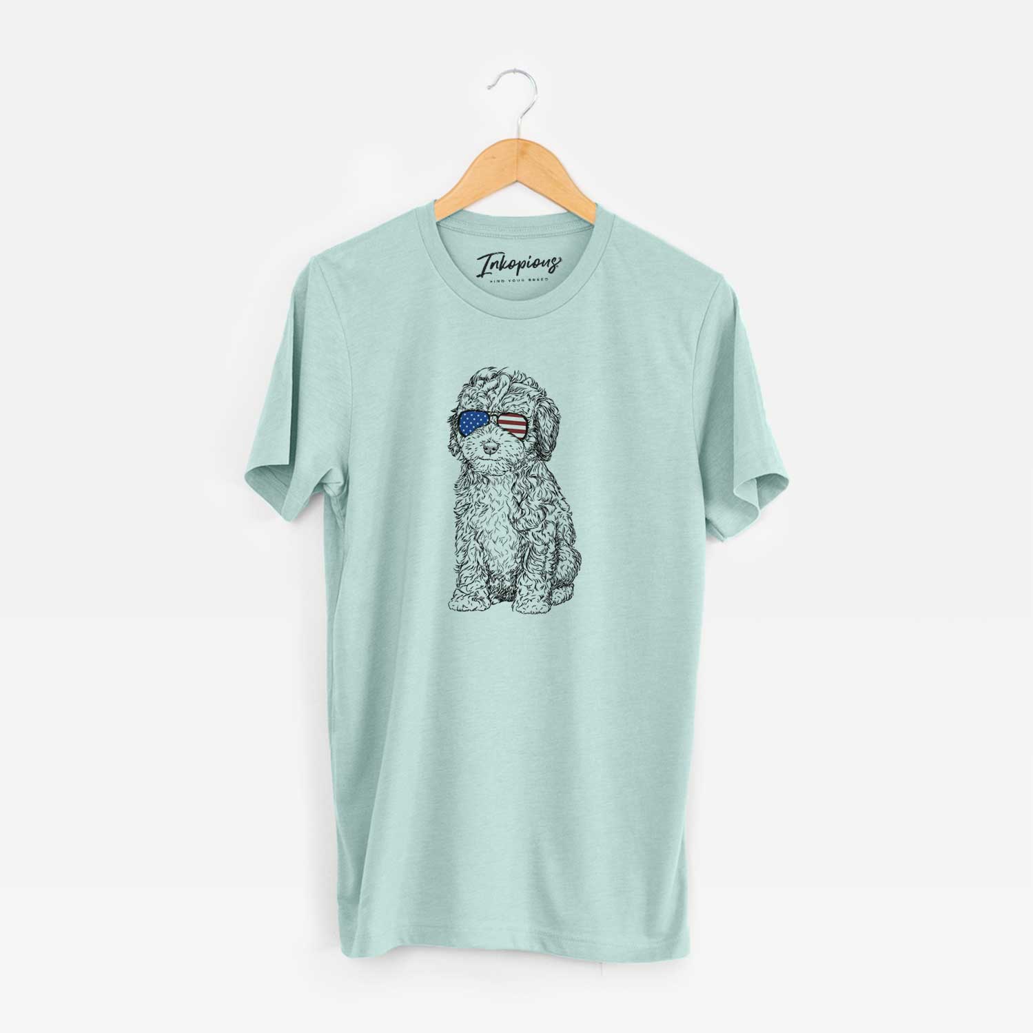 Hand-drawn sketch of Sweet Tea the Mini Doodle wearing American flag sunglasses on a Heather Sage Unisex crewneck