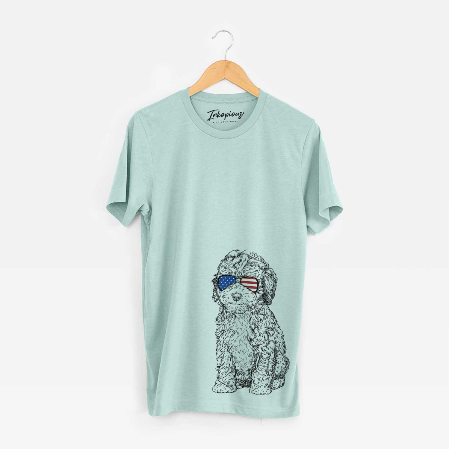 Hand-drawn sketch of Sweet Tea the Mini Doodle wearing American flag sunglasses on a Heather Sage Unisex crewneck