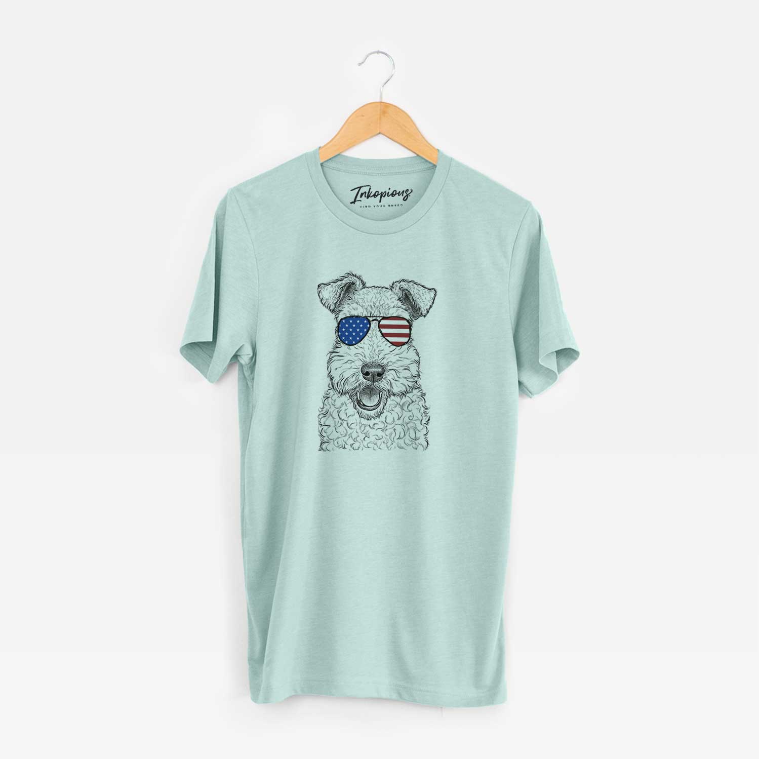 Hand-drawn sketch of Ted the Wire Fox Terrier wearing American flag sunglasses on a Heather Sage Unisex crewneck