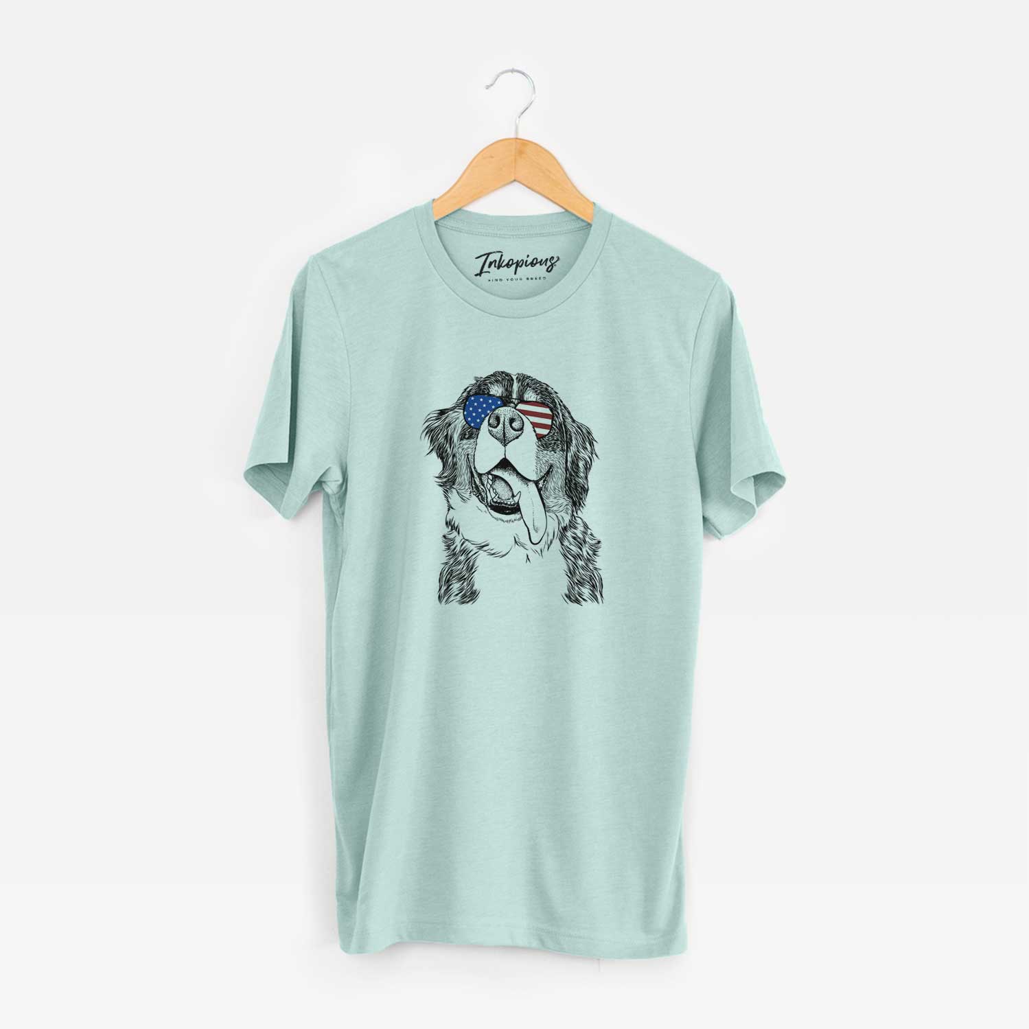 Hand-drawn sketch of Theo the Bernese Mountain Dog wearing American flag sunglasses on a Heather Sage Unisex crewneck