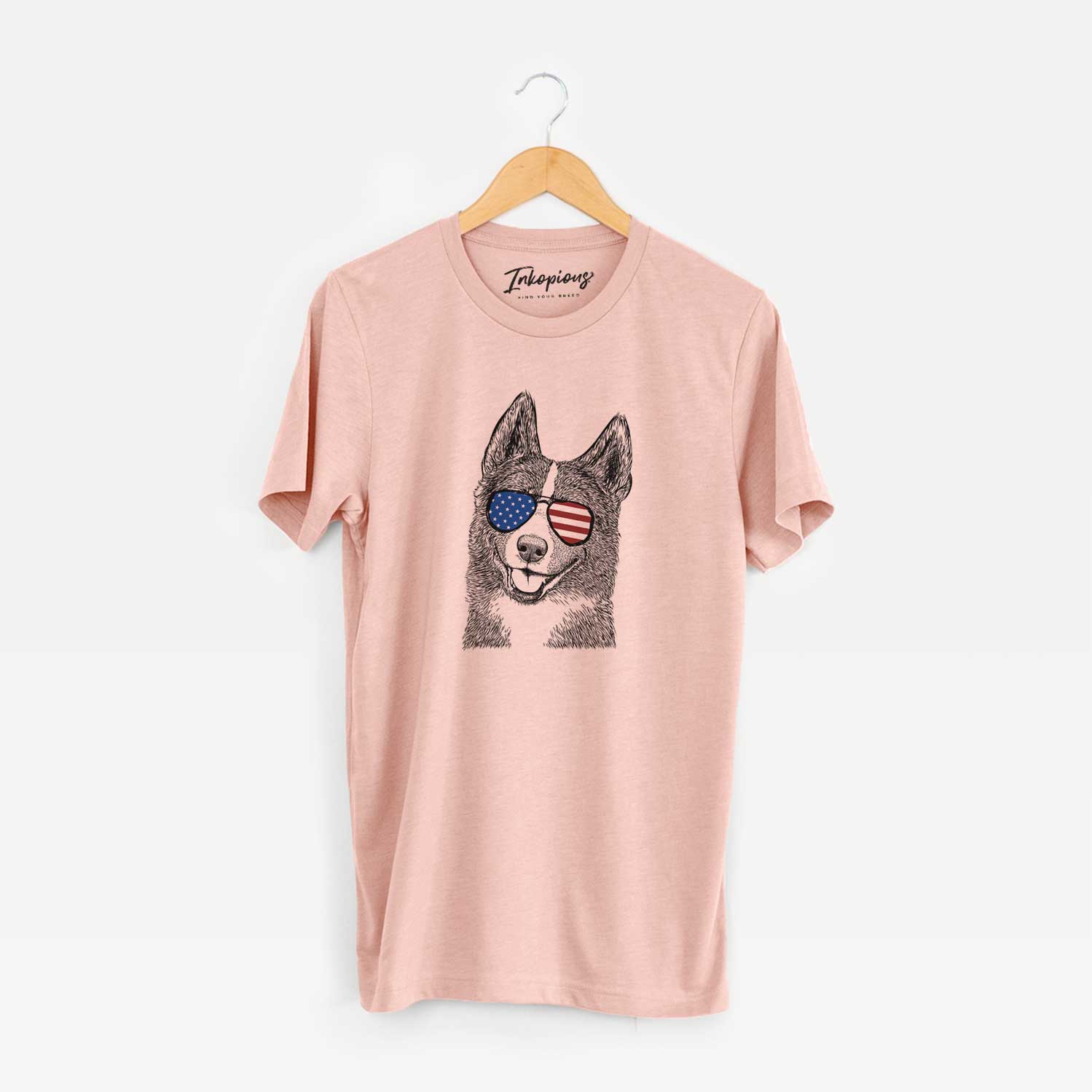 Hand-drawn sketch of Tosca the Karelian Bear Dog wearing American flag sunglasses on a Peach Unisex crewneck