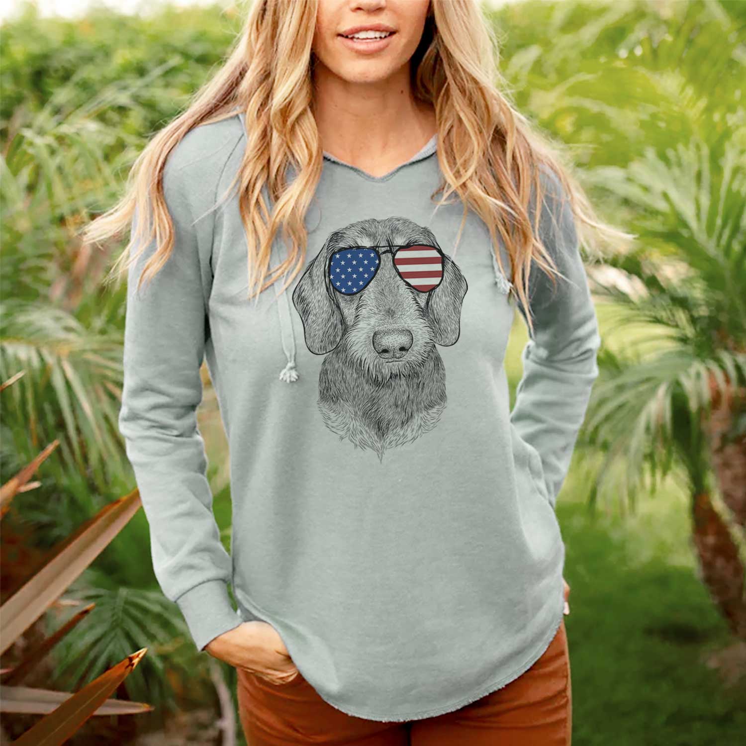 Hand-drawn sketch of Truman the Wirehaired Dachshund wearing American flag sunglasses on a Sage Cali Wave Hooded Sweatshirt, lifestyle photo