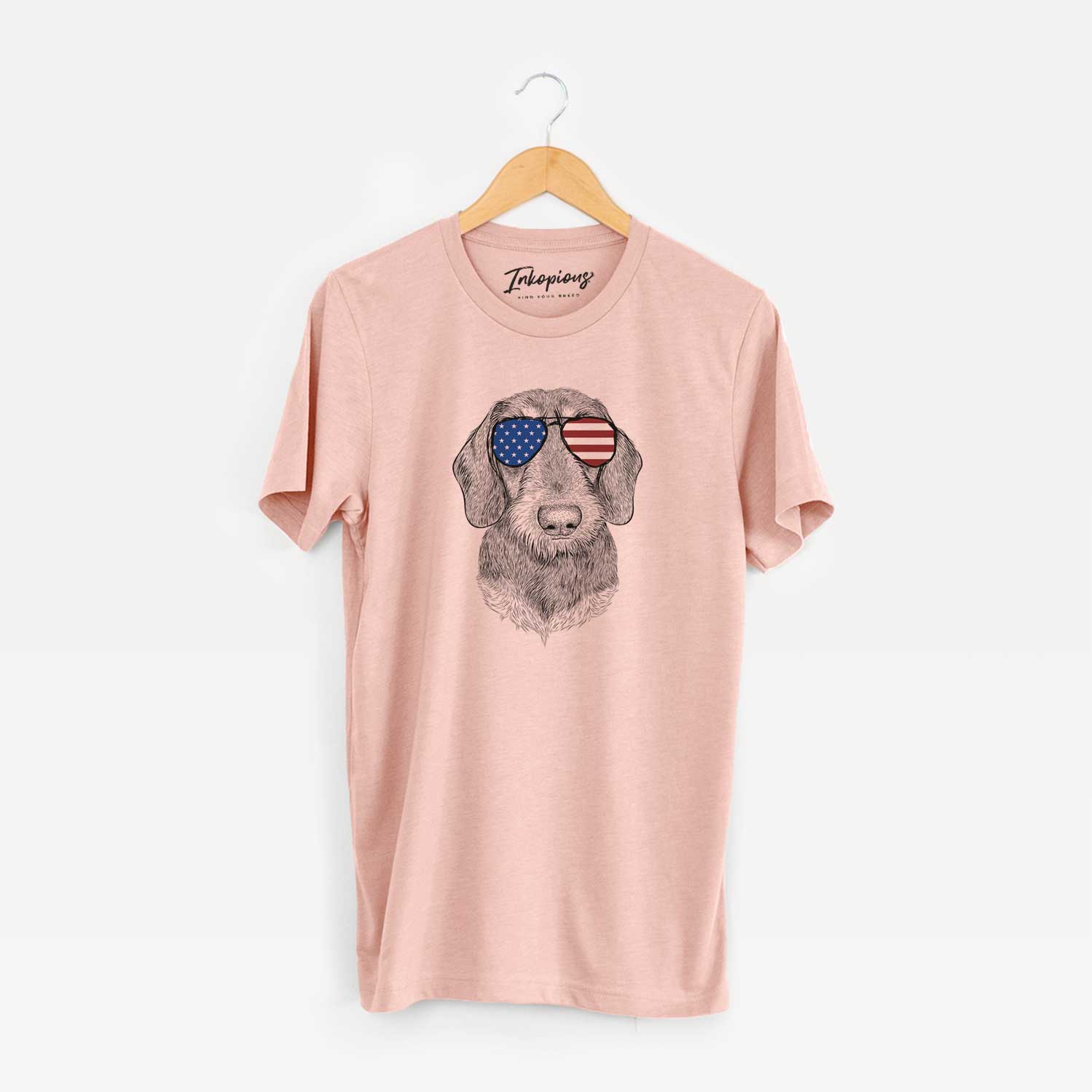 Hand-drawn sketch of Truman the Wirehaired Dachshund wearing American flag sunglasses on a Peach Unisex crewneck
