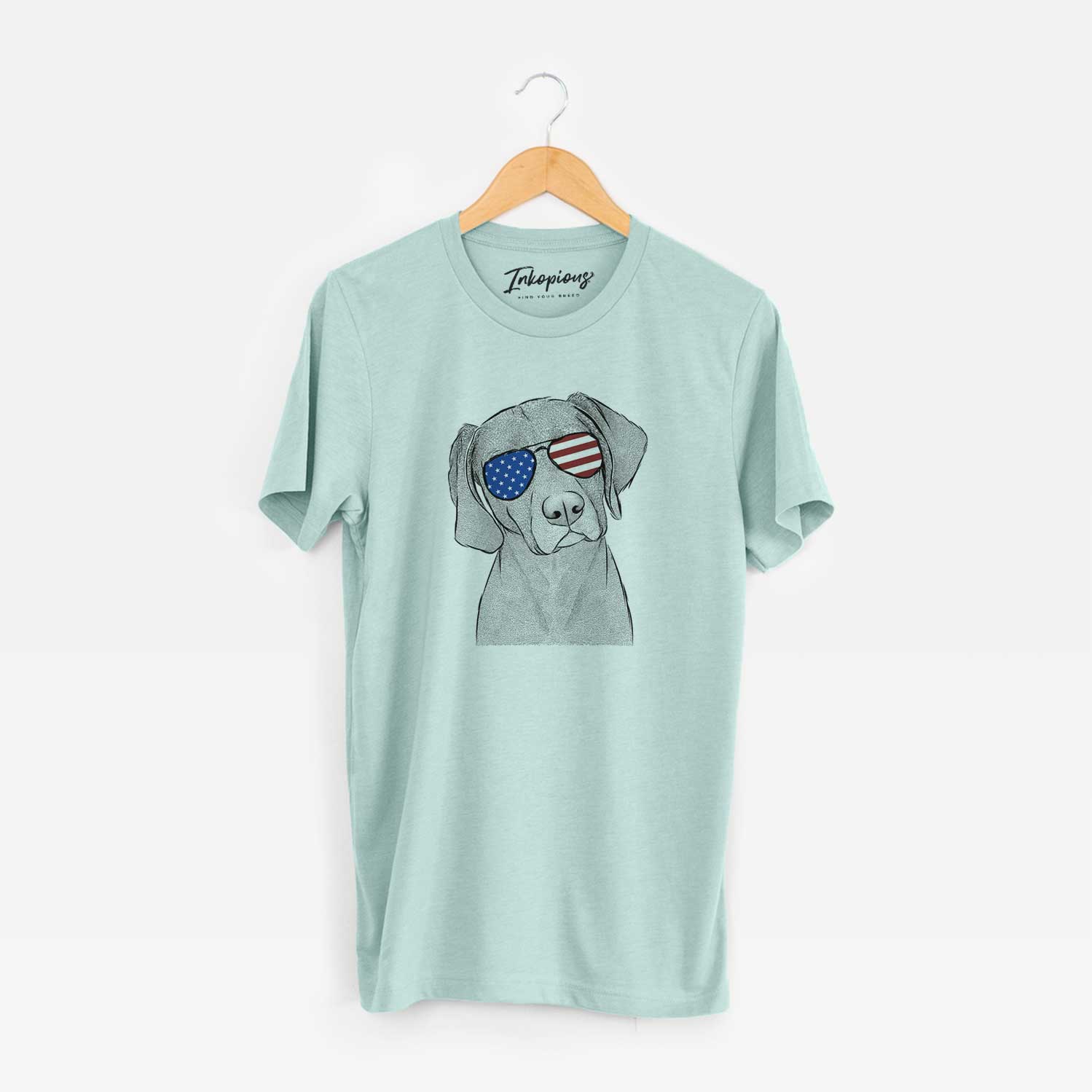 Hand-drawn sketch of Willow the Weizsla wearing American flag sunglasses on a Heather Sage Unisex crewneck