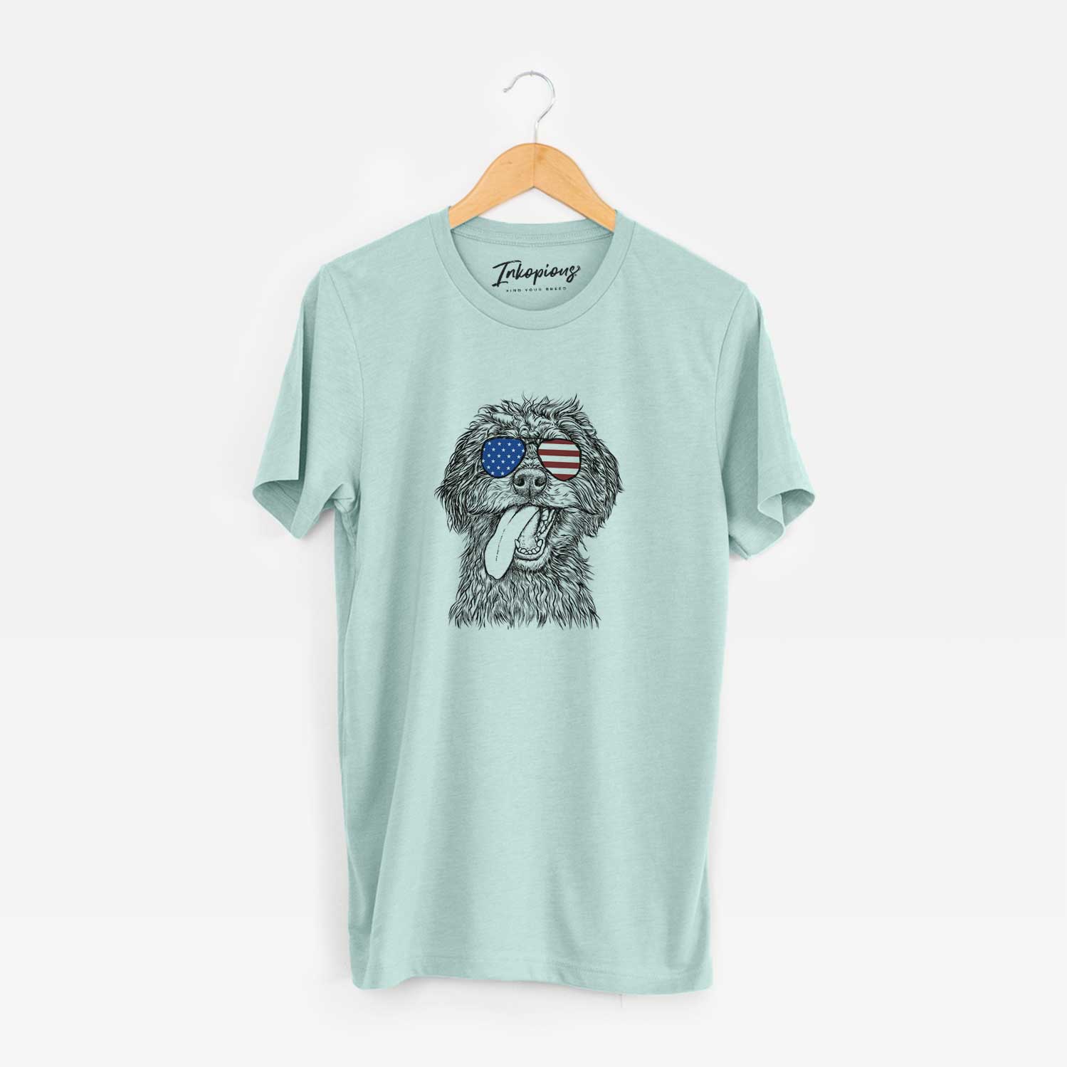 Hand-drawn sketch of Winnie the Mini Aussiedoodle wearing American flag sunglasses on a Heather Sage Unisex crewneck