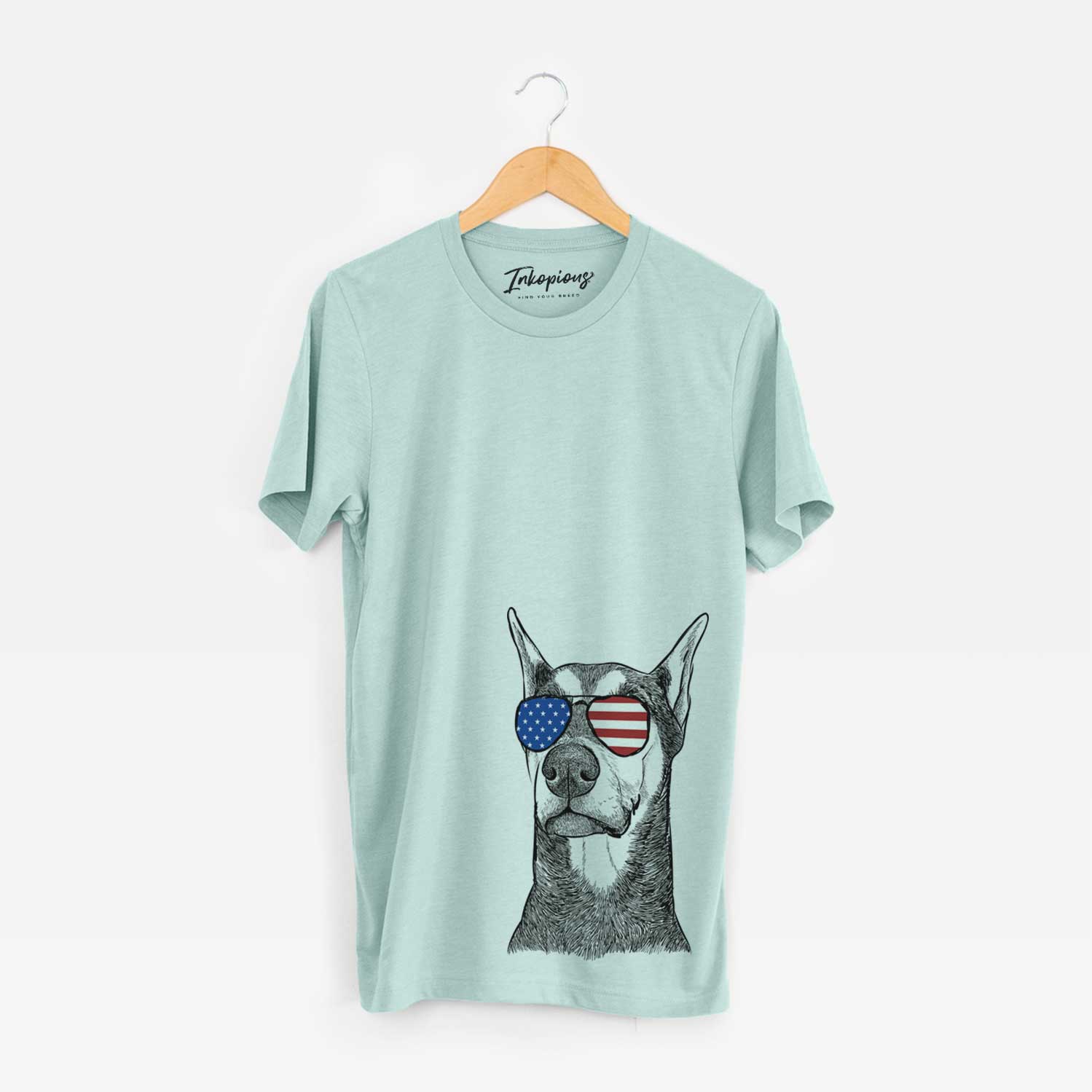 Hand-drawn sketch of Zeus the Doberman Pinscher wearing American flag sunglasses on a Heather Sage Unisex crewneck