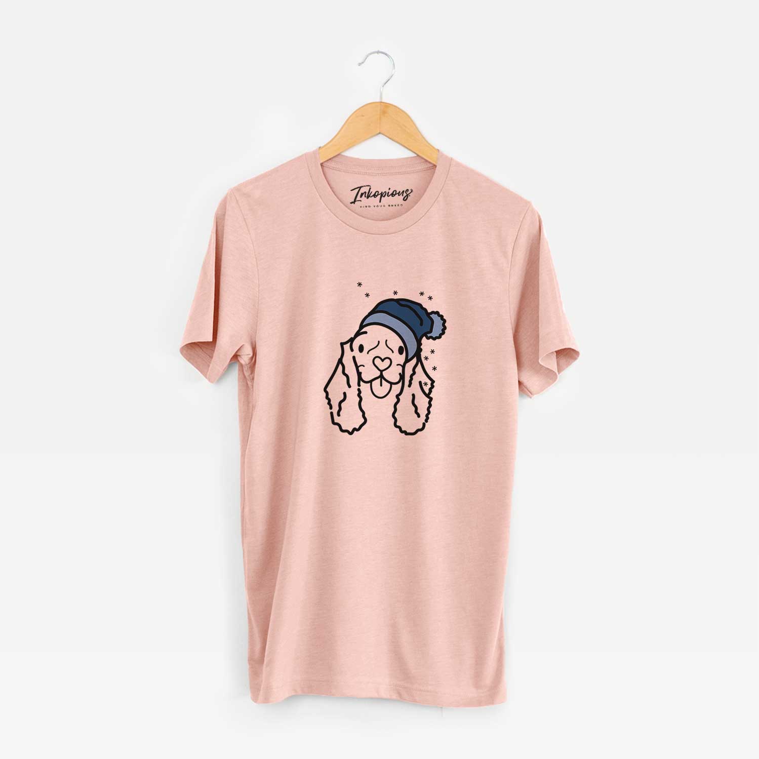 Minimalist line drawing of Bella the American Cocker Spaniel wearing a winter beanie on a Peach Unisex crewneck