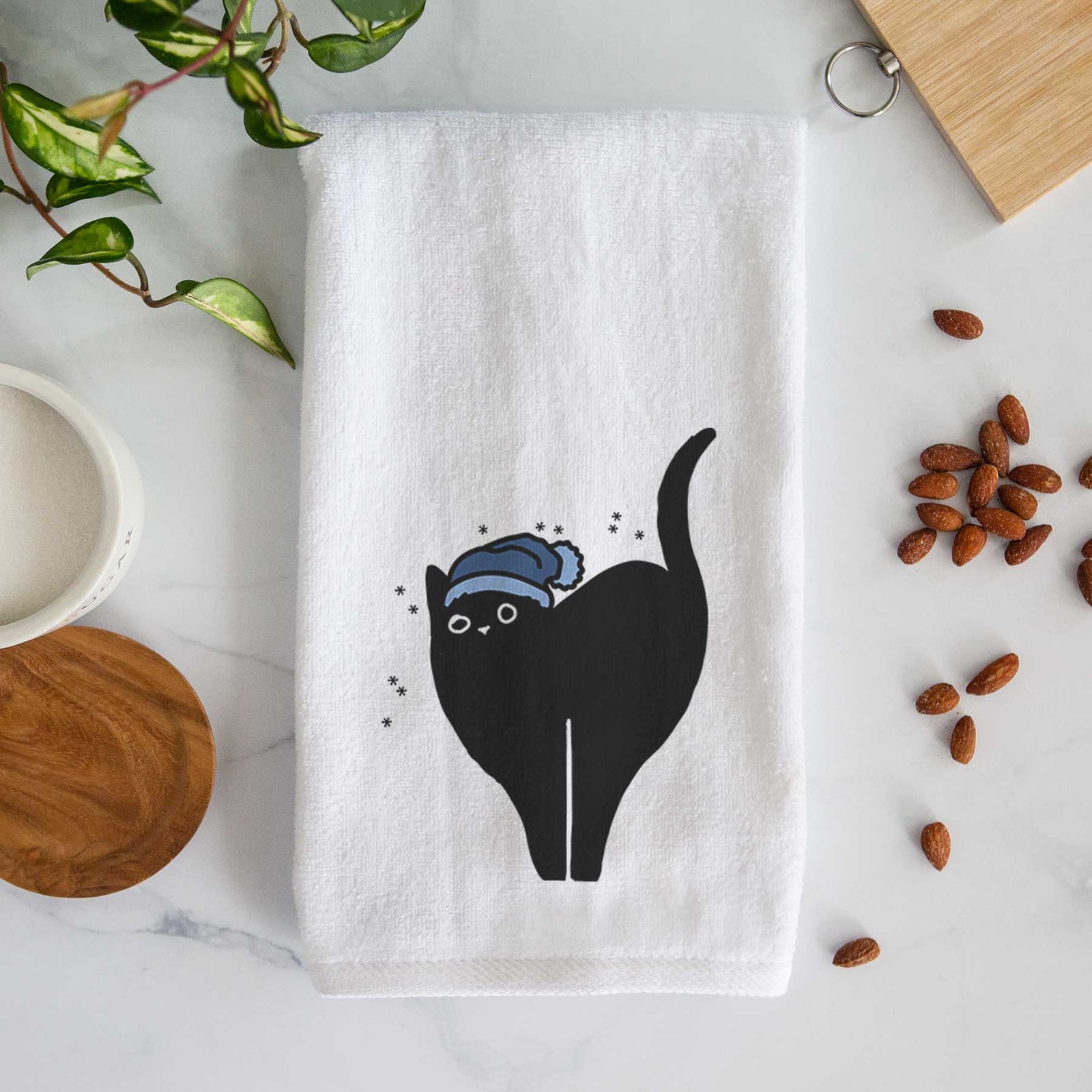 Minimalist line drawing of Bella the Black Cat wearing a winter beanie on a decorative hand towel