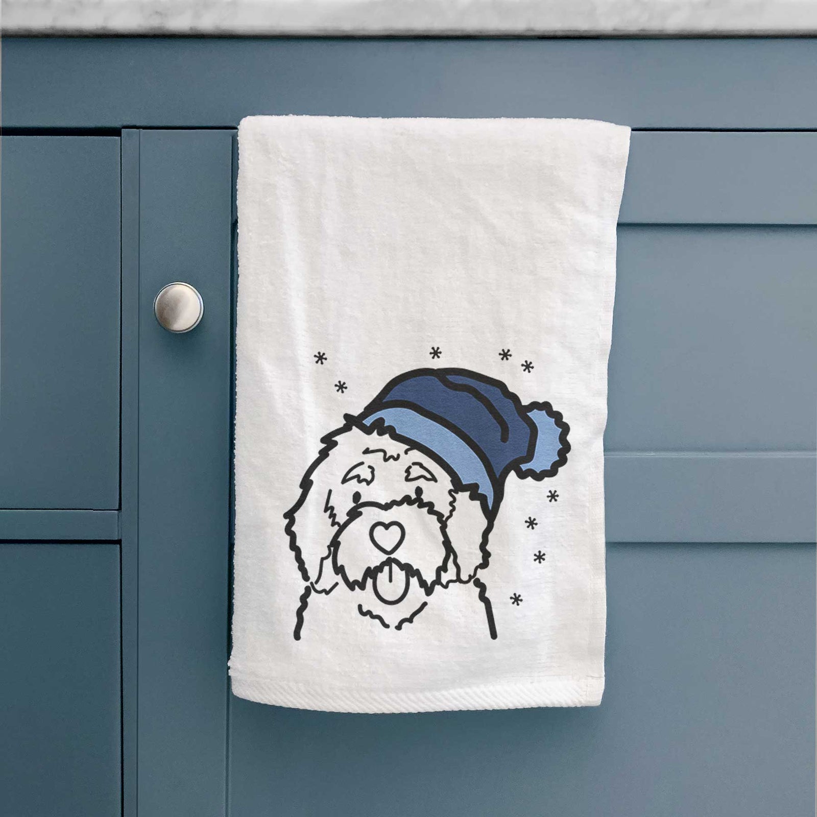 Minimalist line drawing of a Bernedoodle wearing a winter beanie on a decorative hand towel