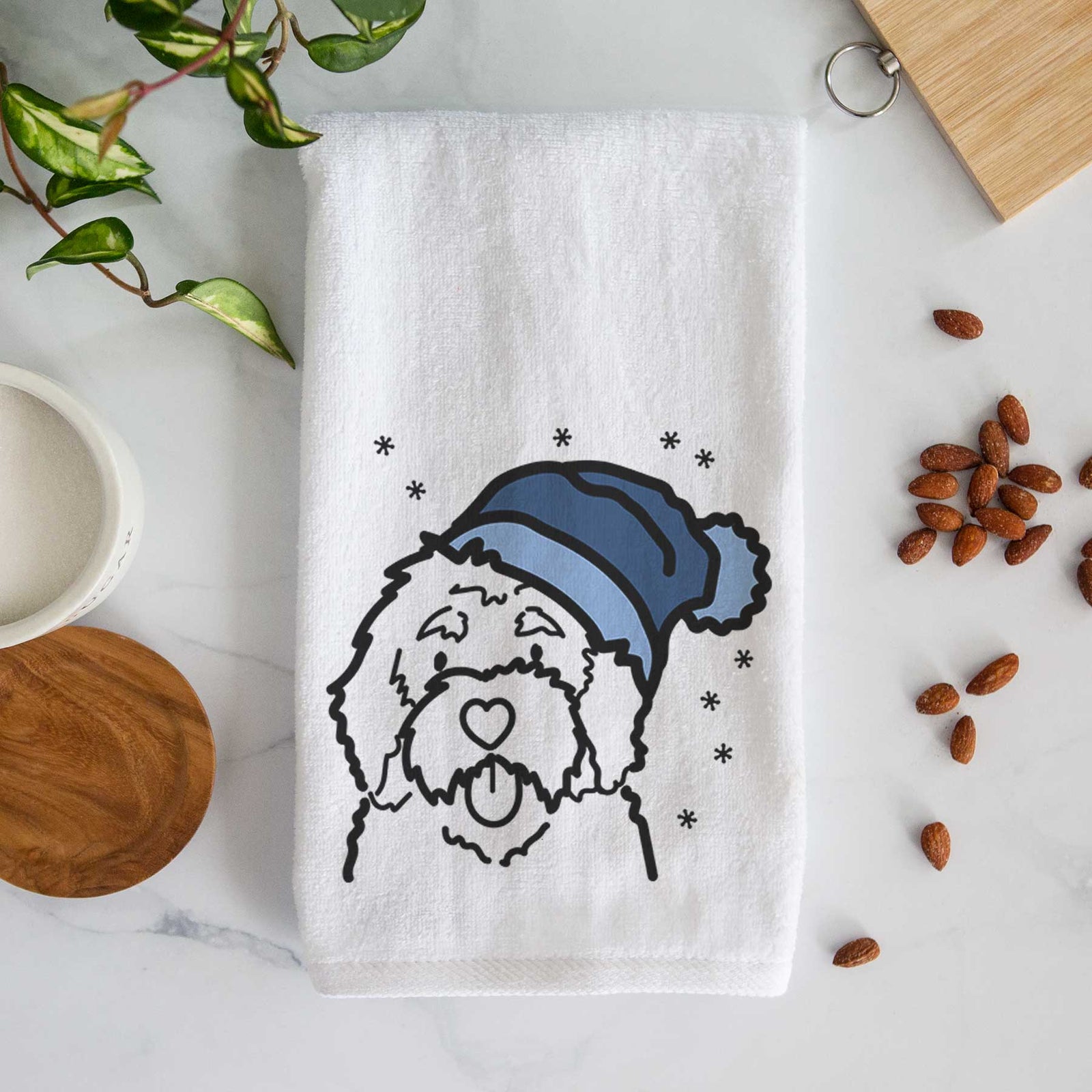 Minimalist line drawing of a Bernedoodle wearing a winter beanie on a decorative hand towel